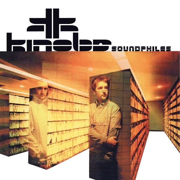 Albumcover. Zwei Männer in einer Bibliothek, mit dem Namen der Band und dem Albumtitel oben.