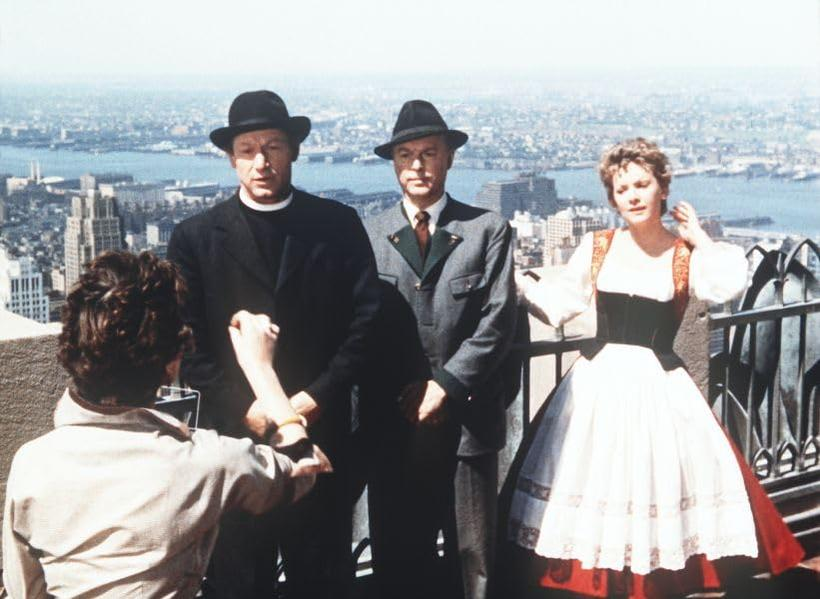 Männer und Frau auf einem Dach mit Blick auf eine Stadt. Ein Mann macht ein Foto. Szene aus einem Film.