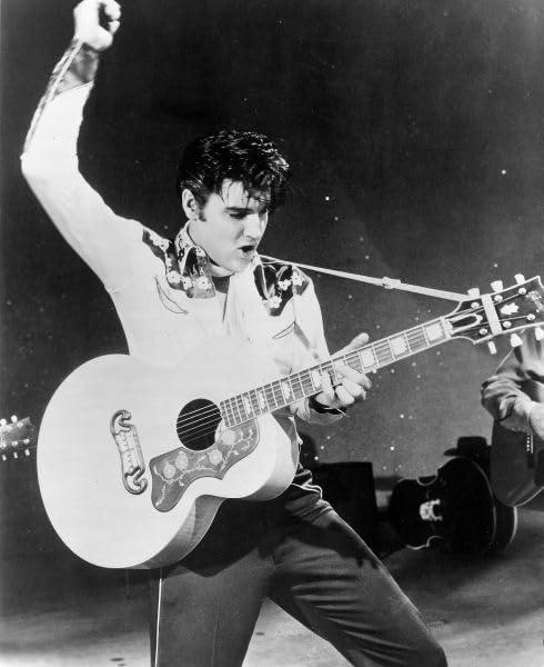 Elvis Presley performt. Gitarre spielen. Schwarz und Weiß. Bühnenbeleuchtung und dunkler Hintergrund.