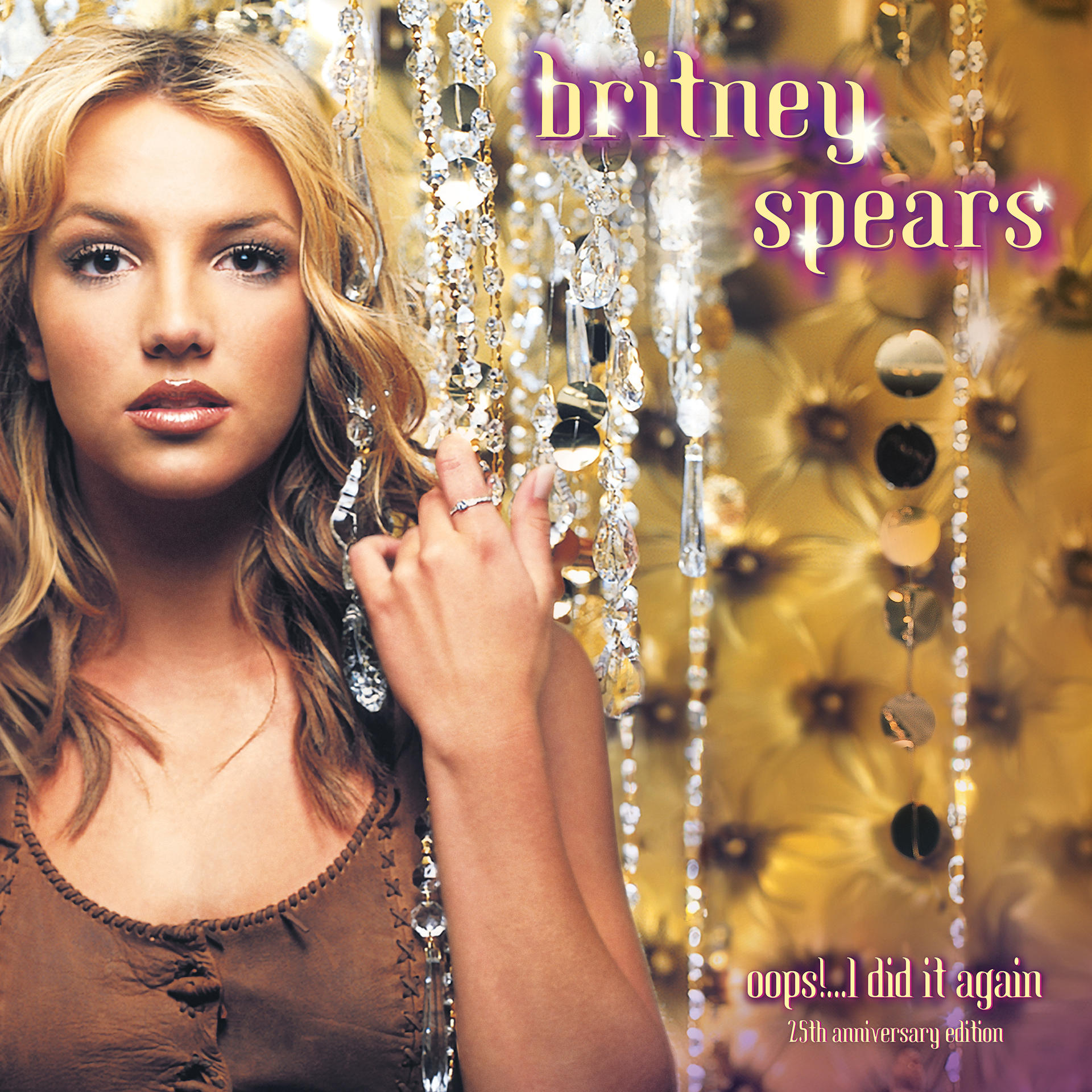 Britney Spears Albumcover. Blonde Frau mit langen Haaren, Schmuck haltend.