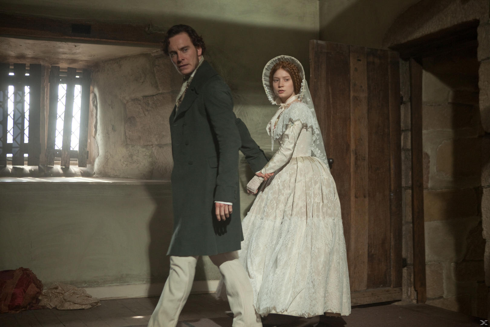 Mann und Frau in historischer Kleidung, halten Hände, in einem Raum.