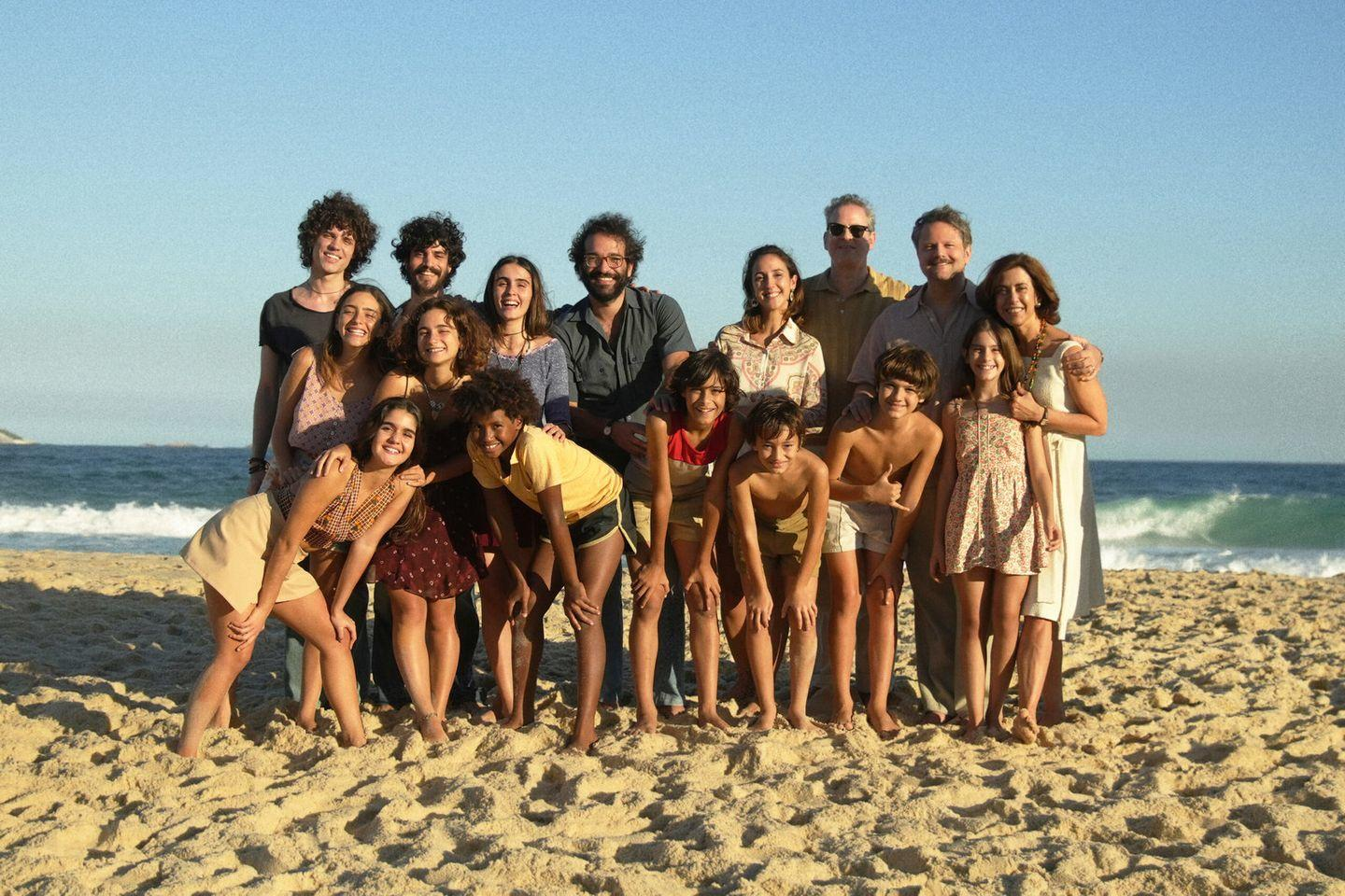 Gruppe von Leuten am Strand. Sand und Ozean im Hintergrund. Sonniger Tag.