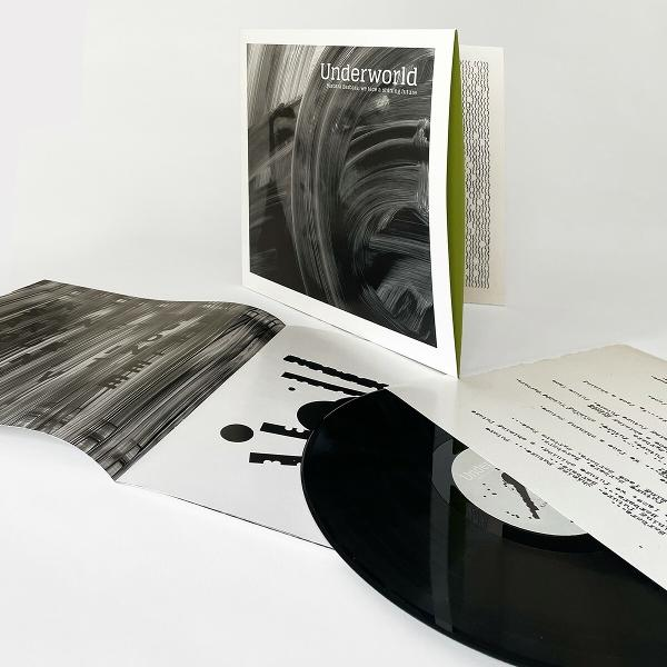 Albumcover mit einer schwarzen Schallplatte, Albumkunst und Text. Weißer Hintergrund.