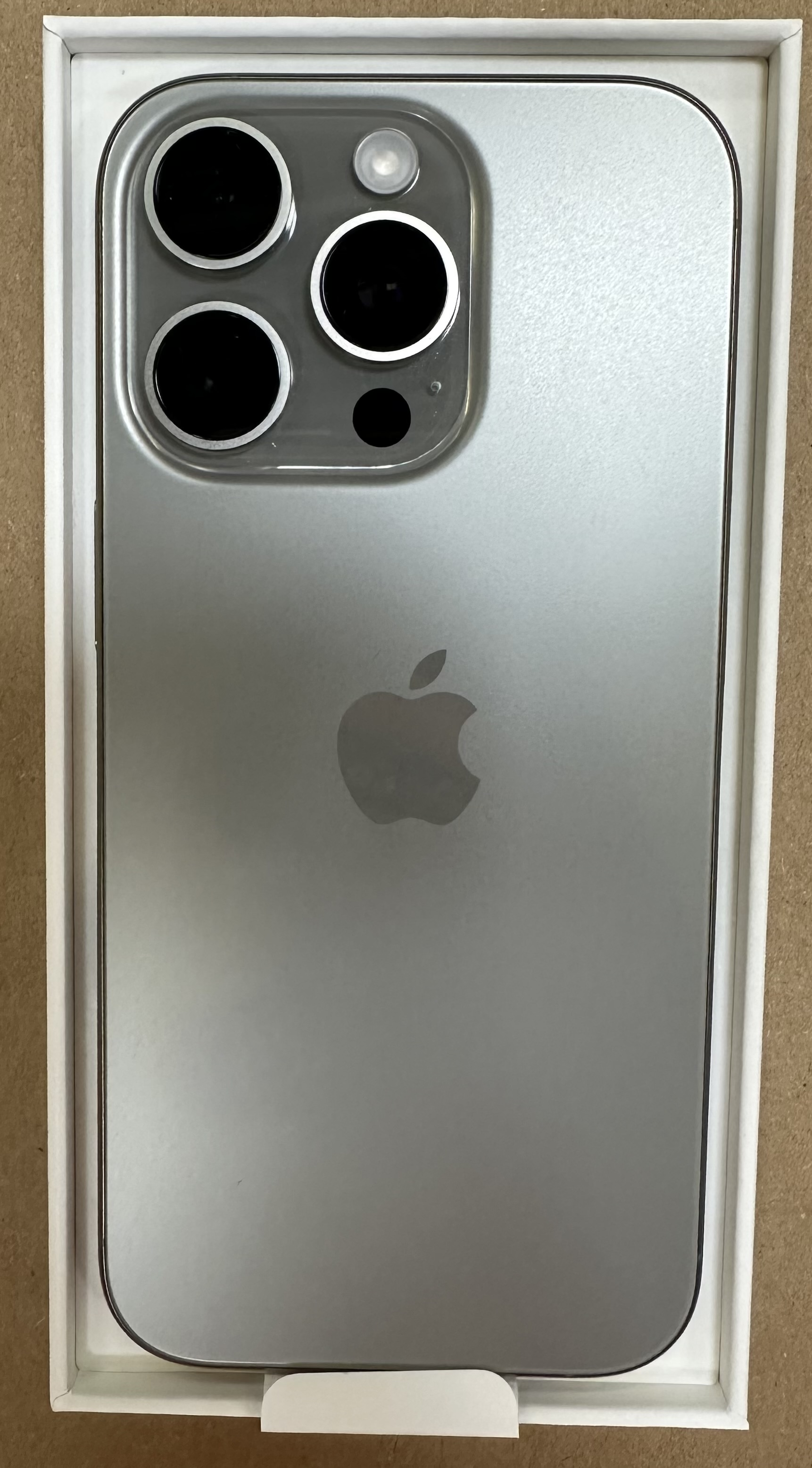 Tył srebrnego smartfona w białym pudełku. Widoczne obiektywy aparatu.