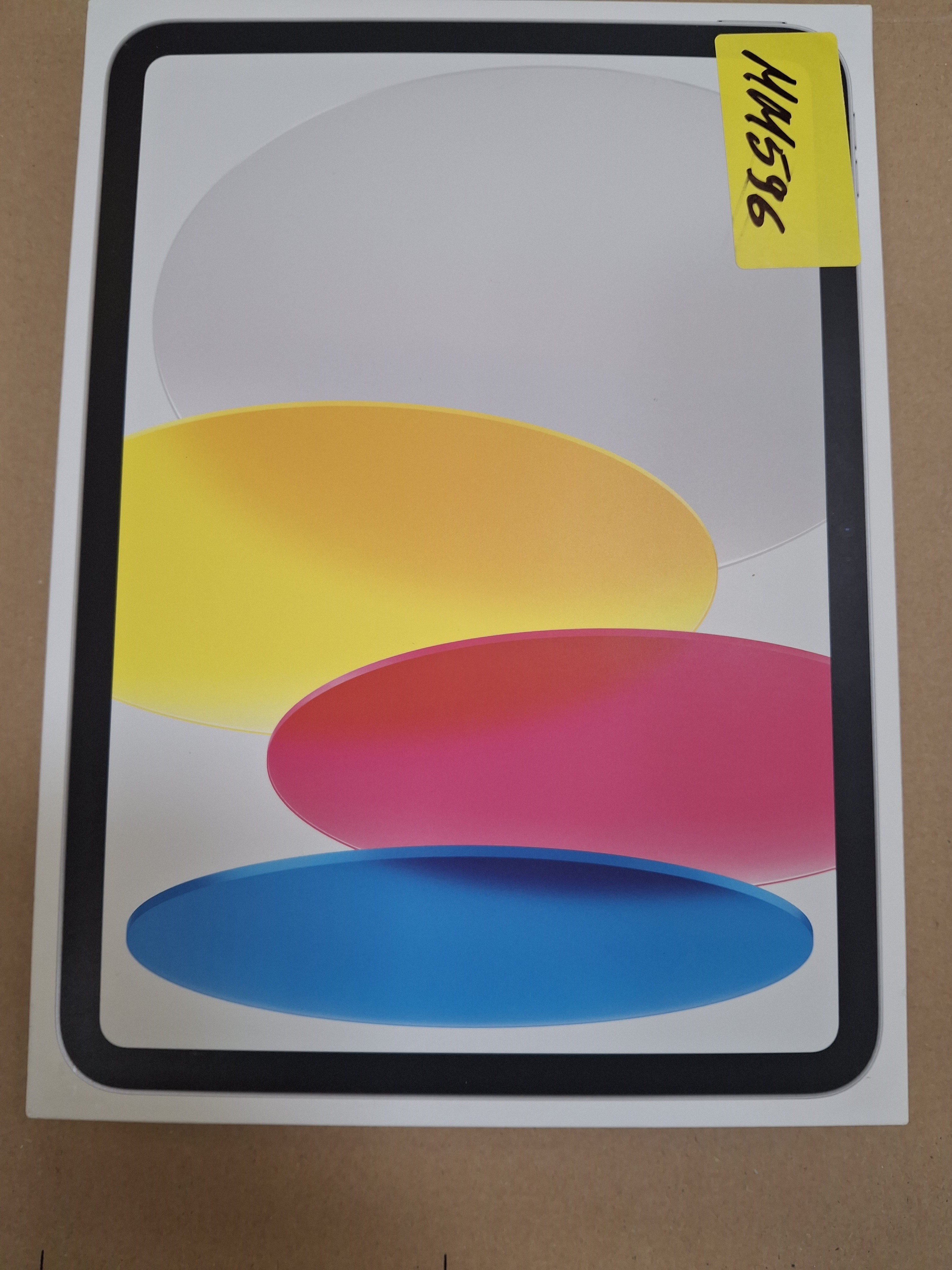 Pudełko tabletu z kolorowymi kształtami z przodu i żółtą etykietą.