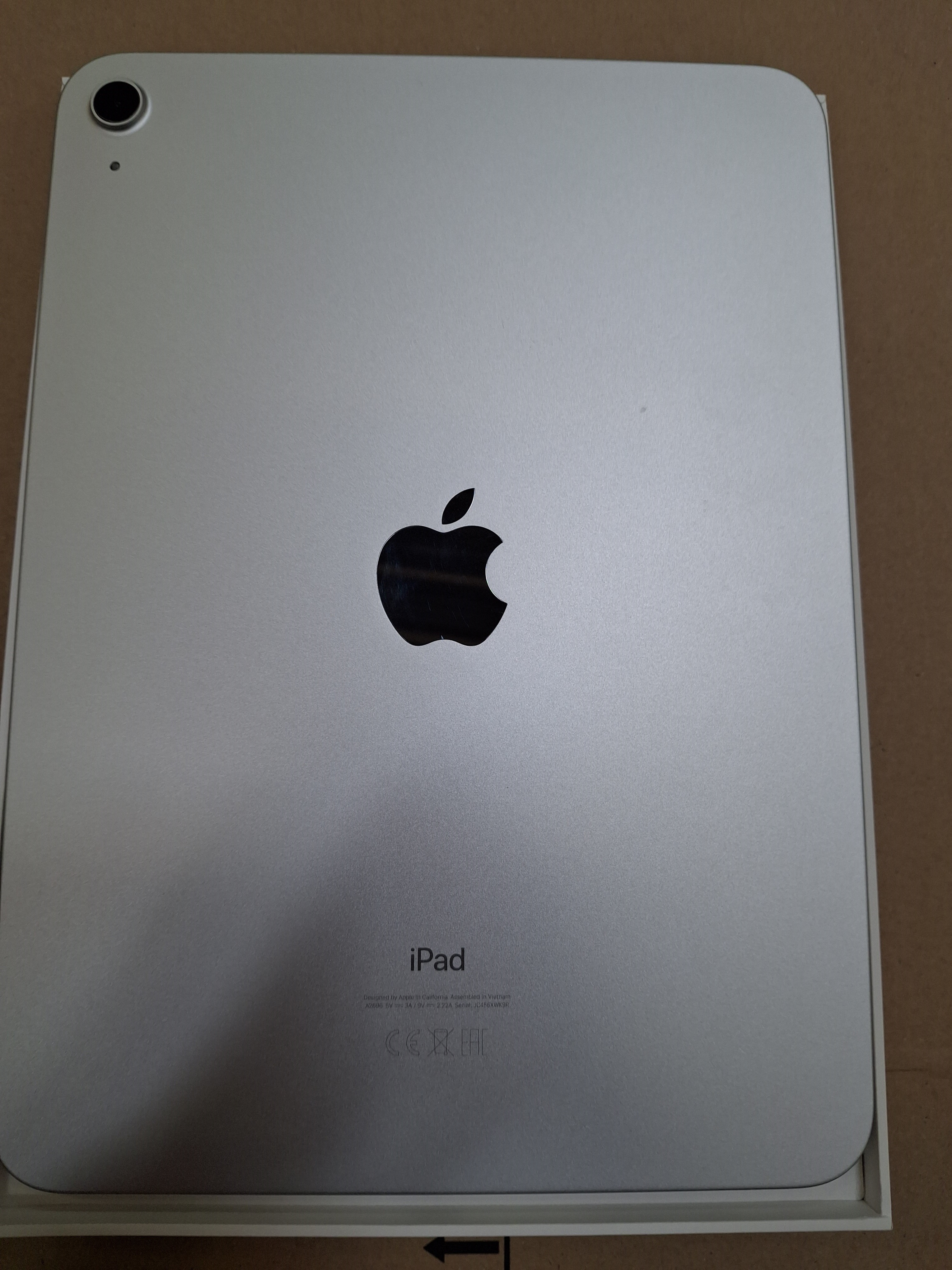 Tył iPada w pudełku, z logo Apple i napisem 'iPad'.