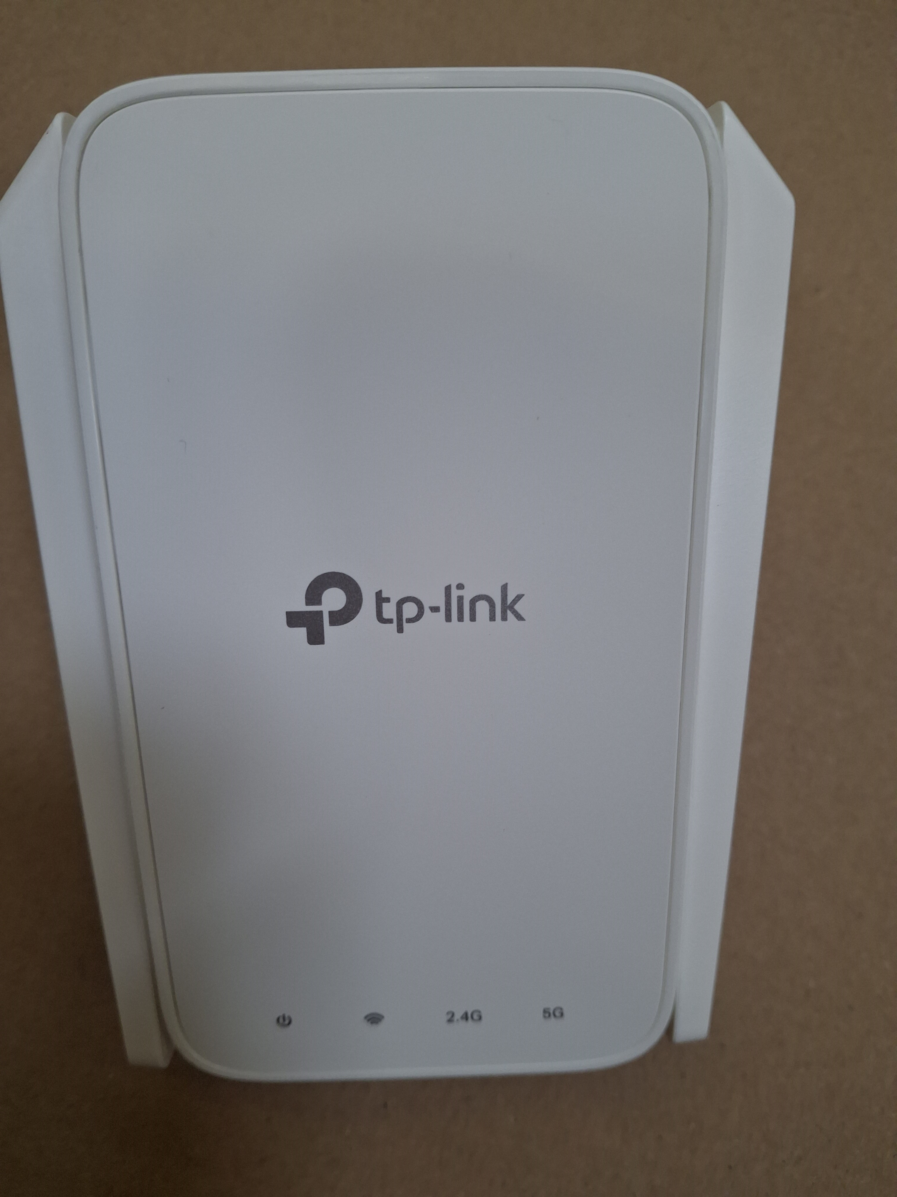 Biały wzmacniacz Wi-Fi. Posiada trzy diody sygnalizujące połączenie.