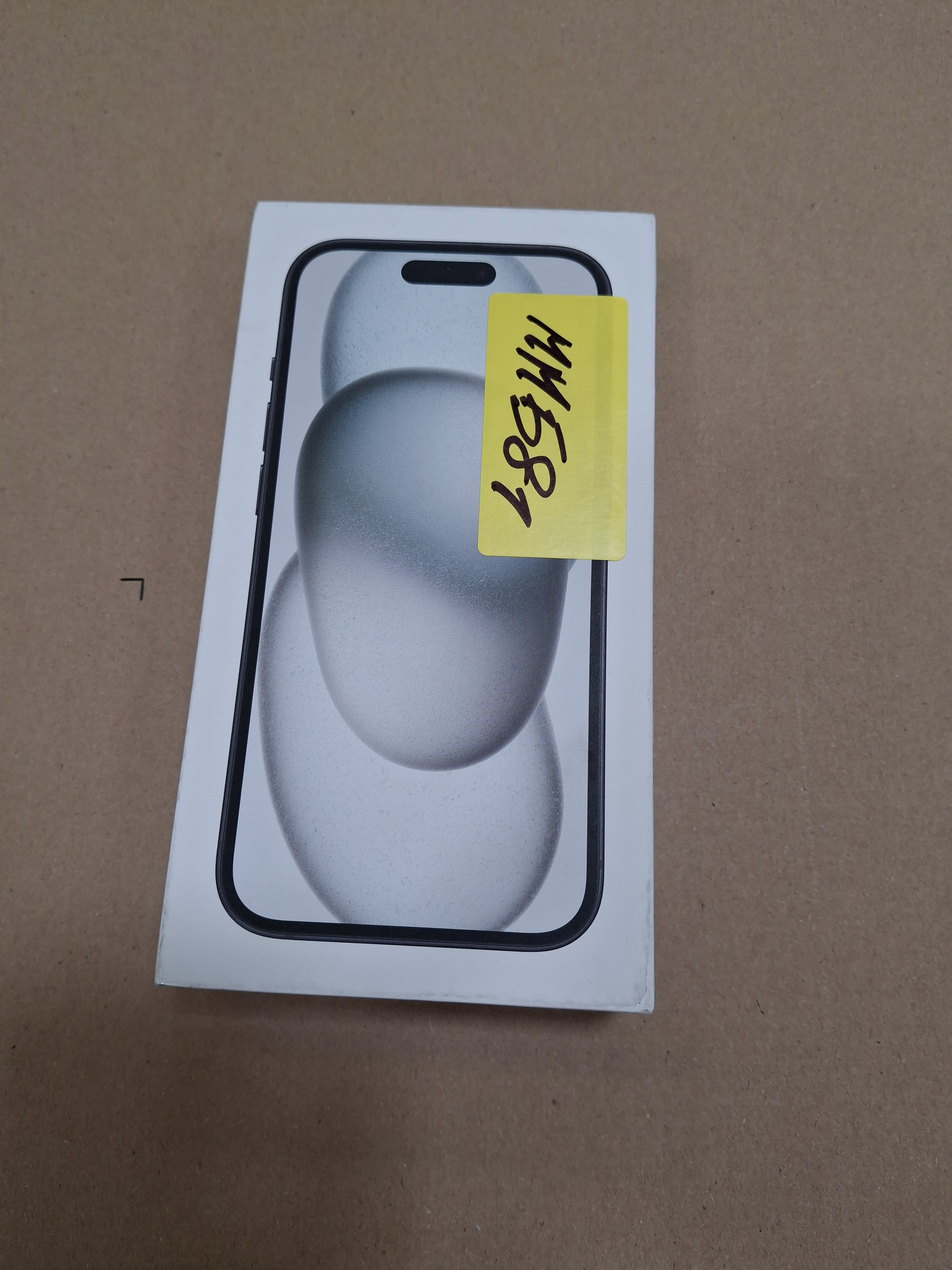 Białe pudełko ze zdjęciem iPhone'a. Na górze pudełka znajduje się żółta naklejka.