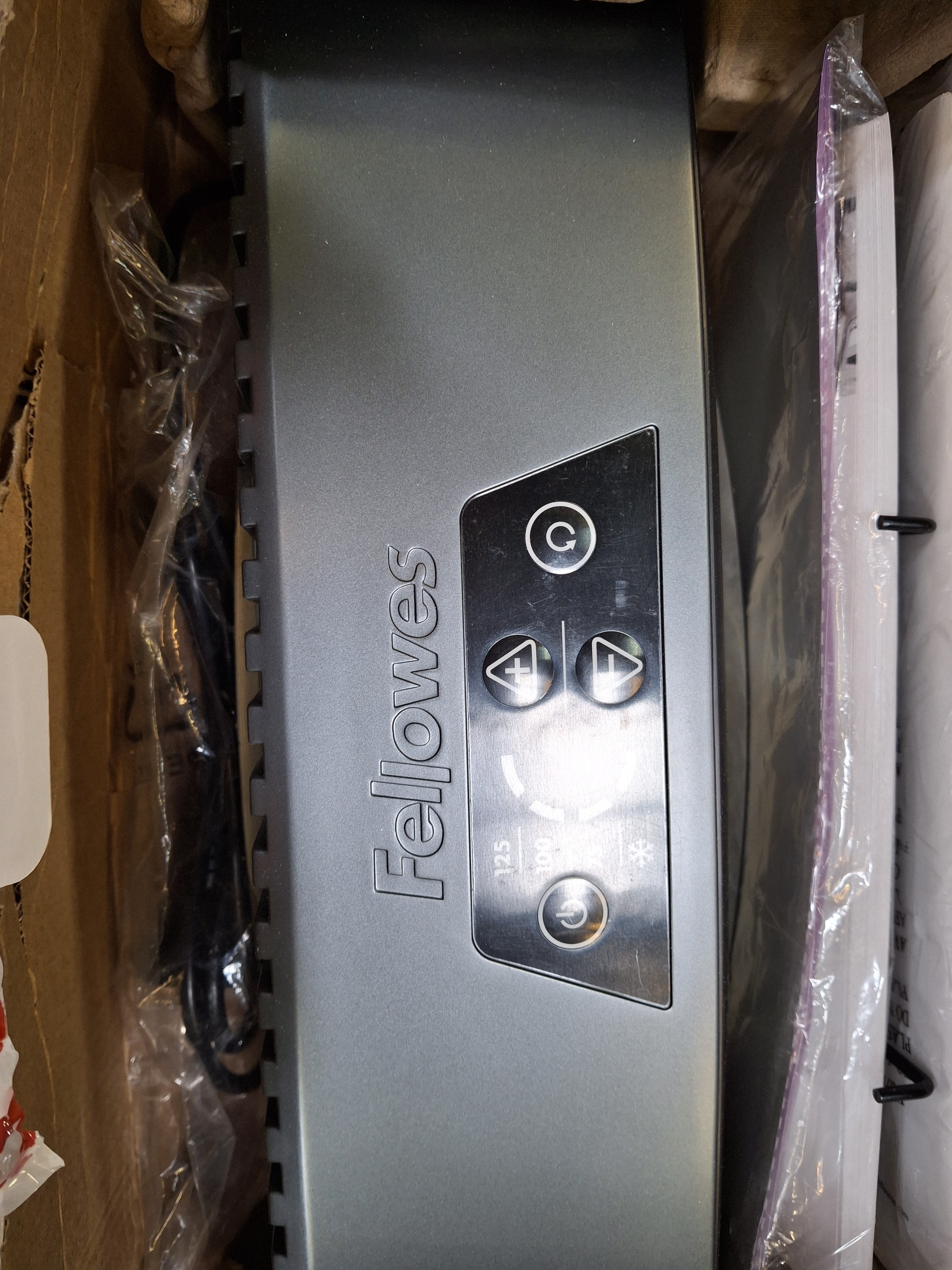 Laminator Fellowes w kartonie. Widok z góry z przyciskami i instrukcjami.