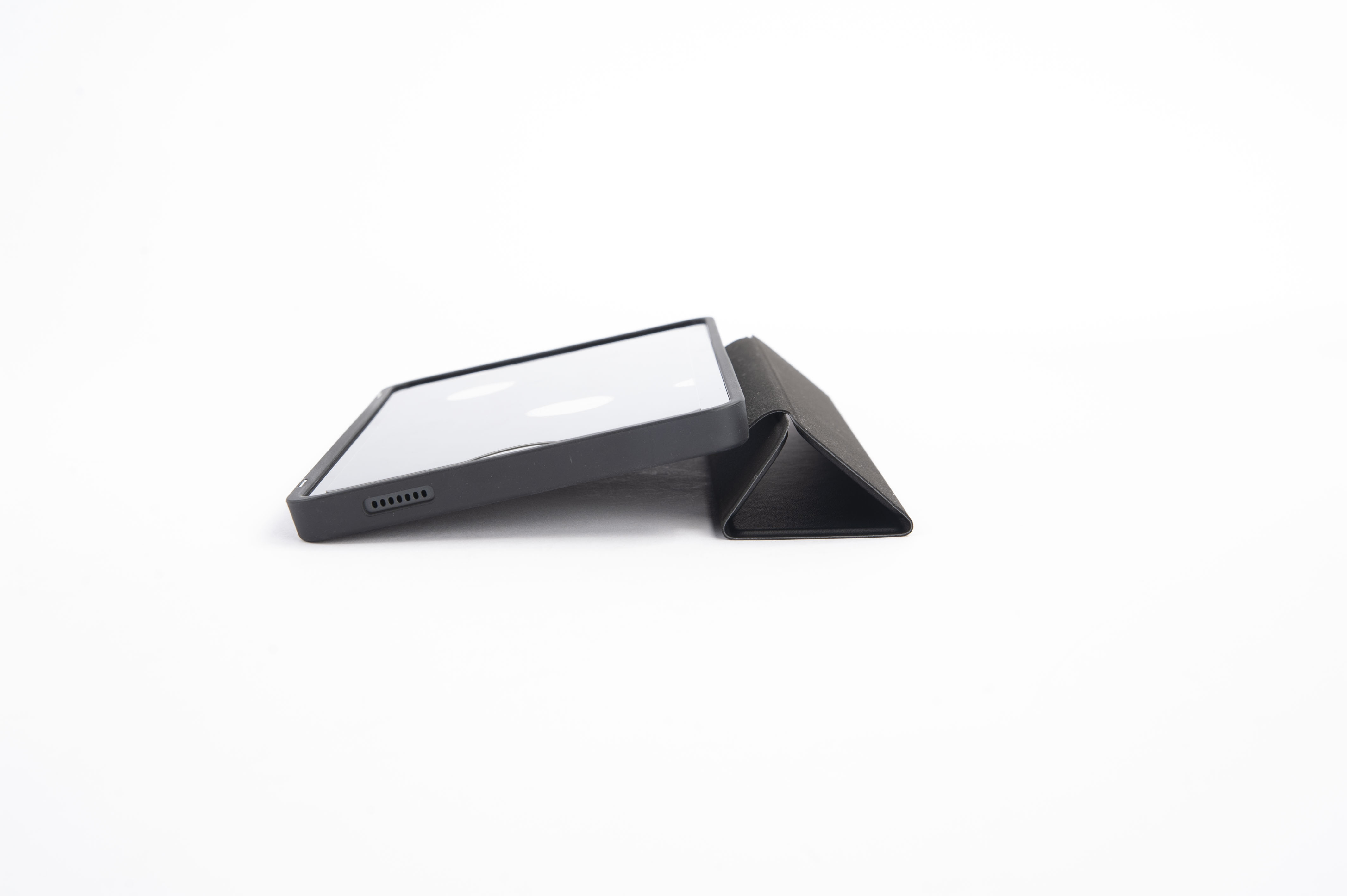 Ein schwarzes Tablet mit Hülle liegt auf weißem Untergrund.