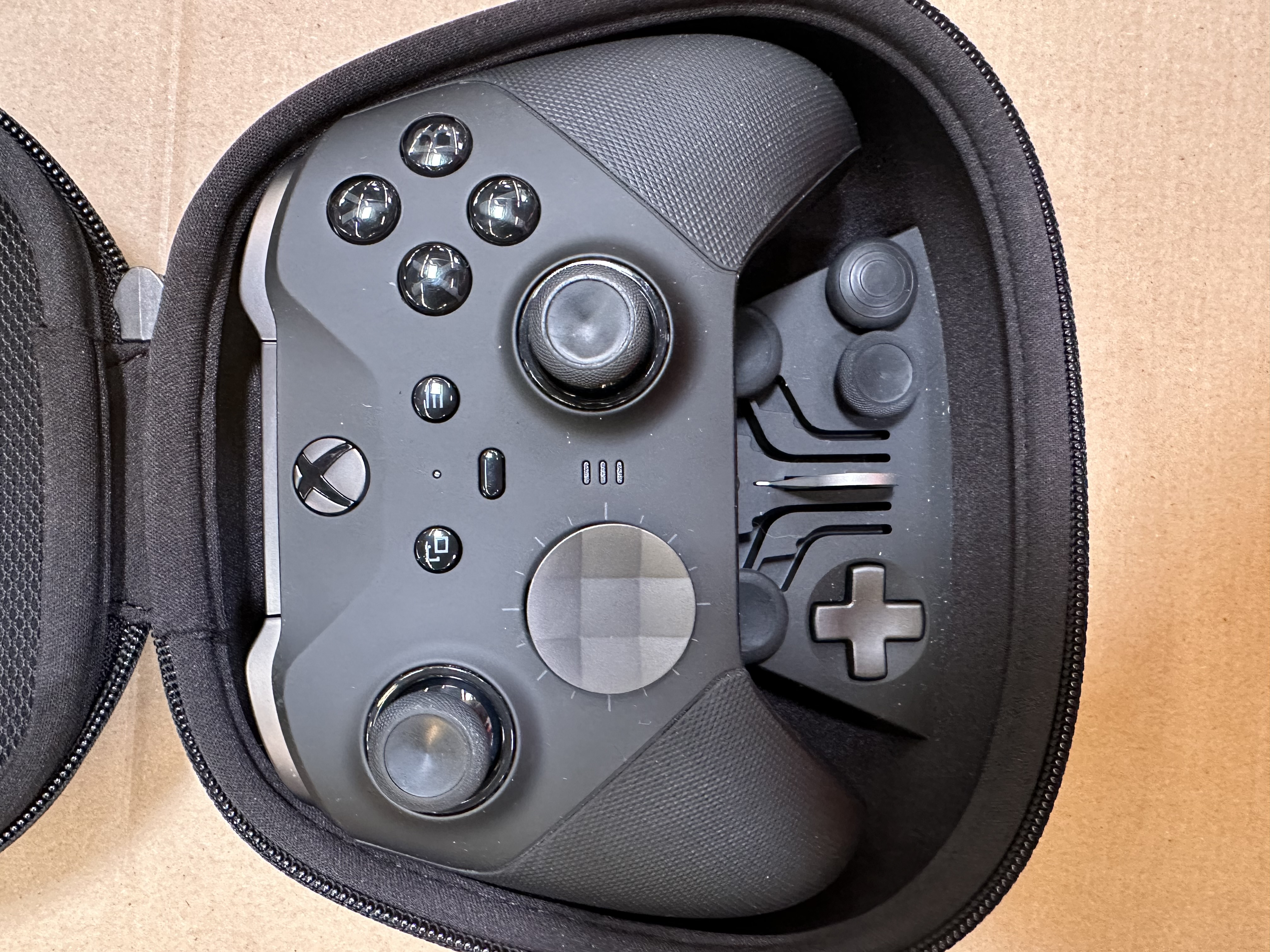 Czarny kontroler Xbox Elite Series 2 w czarnym etui. Kontroler ma widoczne przyciski i joysticki.