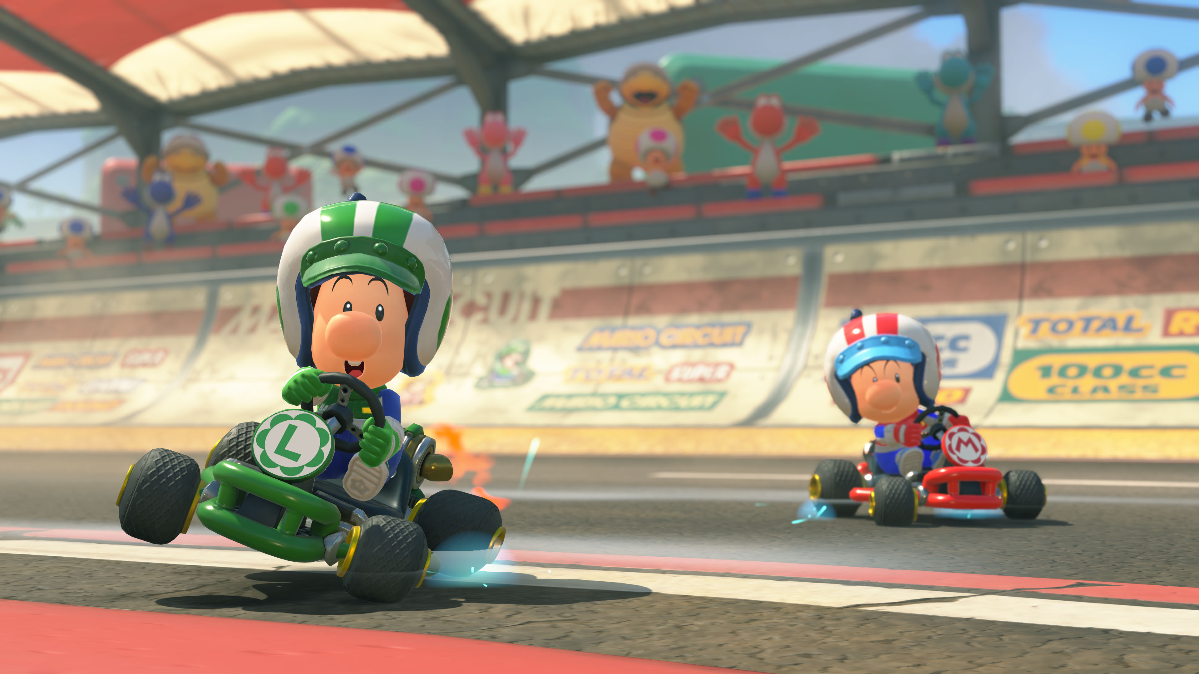 İki çizgi film karakteri, bir pistte go-kart yarışması yapıyor. Arka planda çeşitli karakterler.