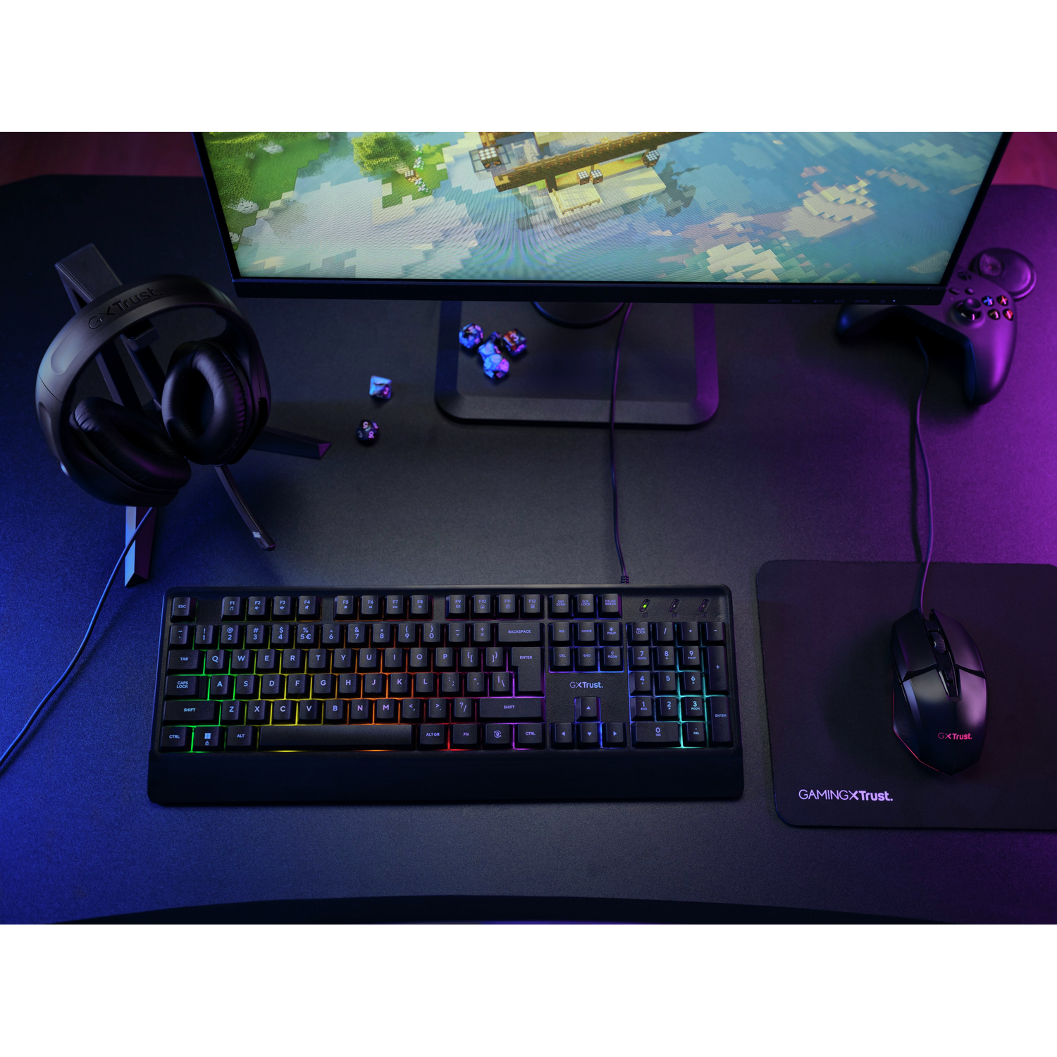 Gaming-opstelling met toetsenbord, muis, hoofdtelefoon en monitor. Het toetsenbord gloeit met kleur.