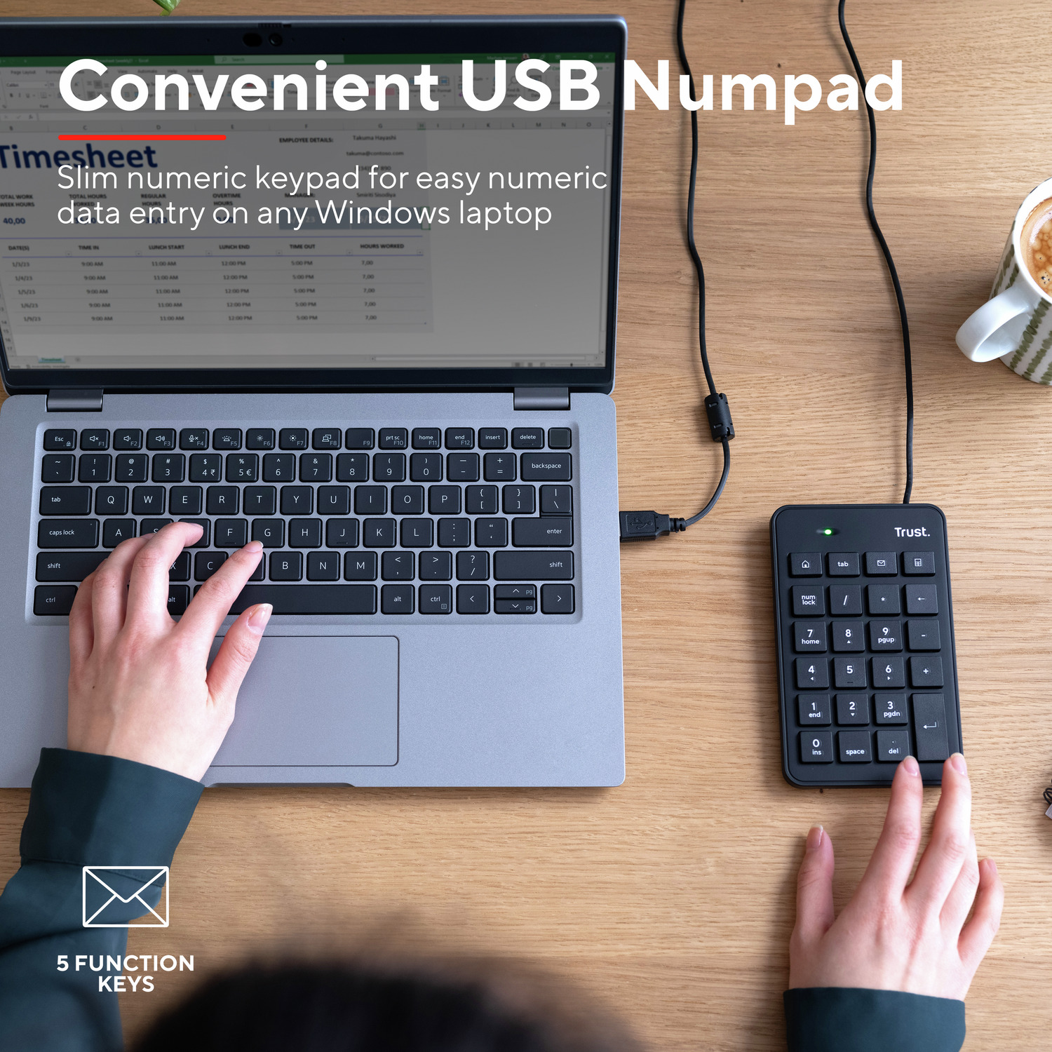 A laptop with a connected numpad next to it. A person's hands are using the numpad.