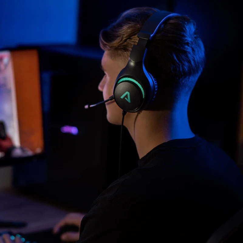 Egy férfi fekete gamer headsetet visel mikrofonnal, miközben videojátékot játszik.
