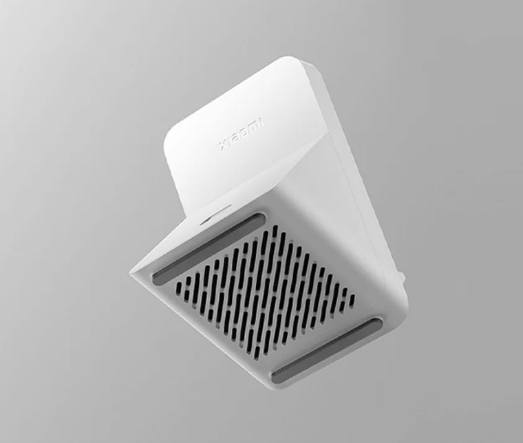 Białe prostokątne urządzenie, widok od dołu, z otworami wentylacyjnymi i podkładkami. Widoczne logo Xiaomi.