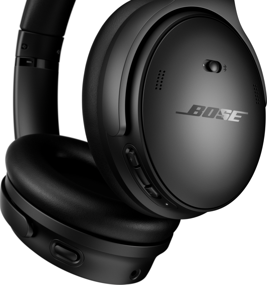 Primo piano di cuffie nere su sfondo nero. Logo Bose visibile.