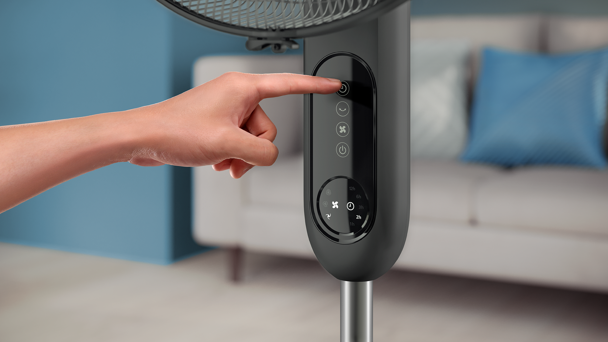 Egy személy keze megnyomja a bekapcsológombot egy sötétszürke Philips ventilátoron. A háttér elmosódott.