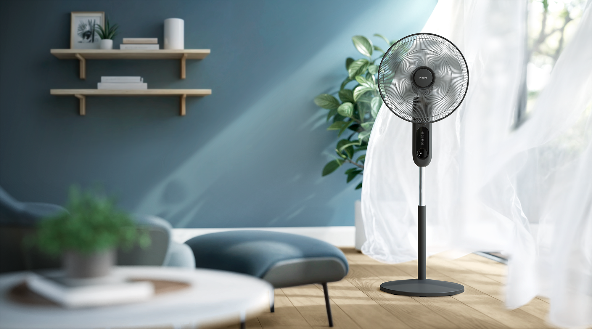 Sötétszürke Philips ventilátor egy szobában. Növény és függöny a háttérben. Kék fal.