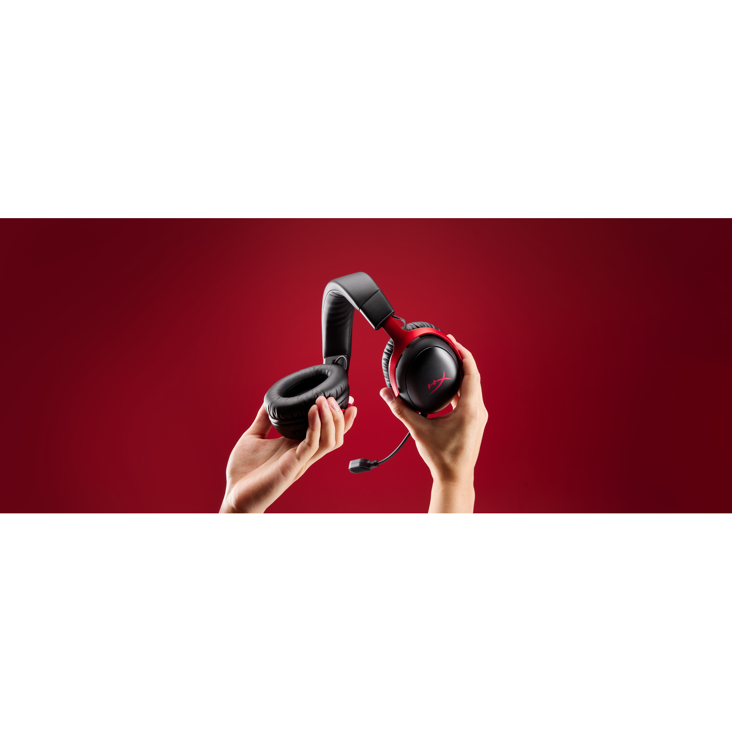Hands holding a black and red headset.
