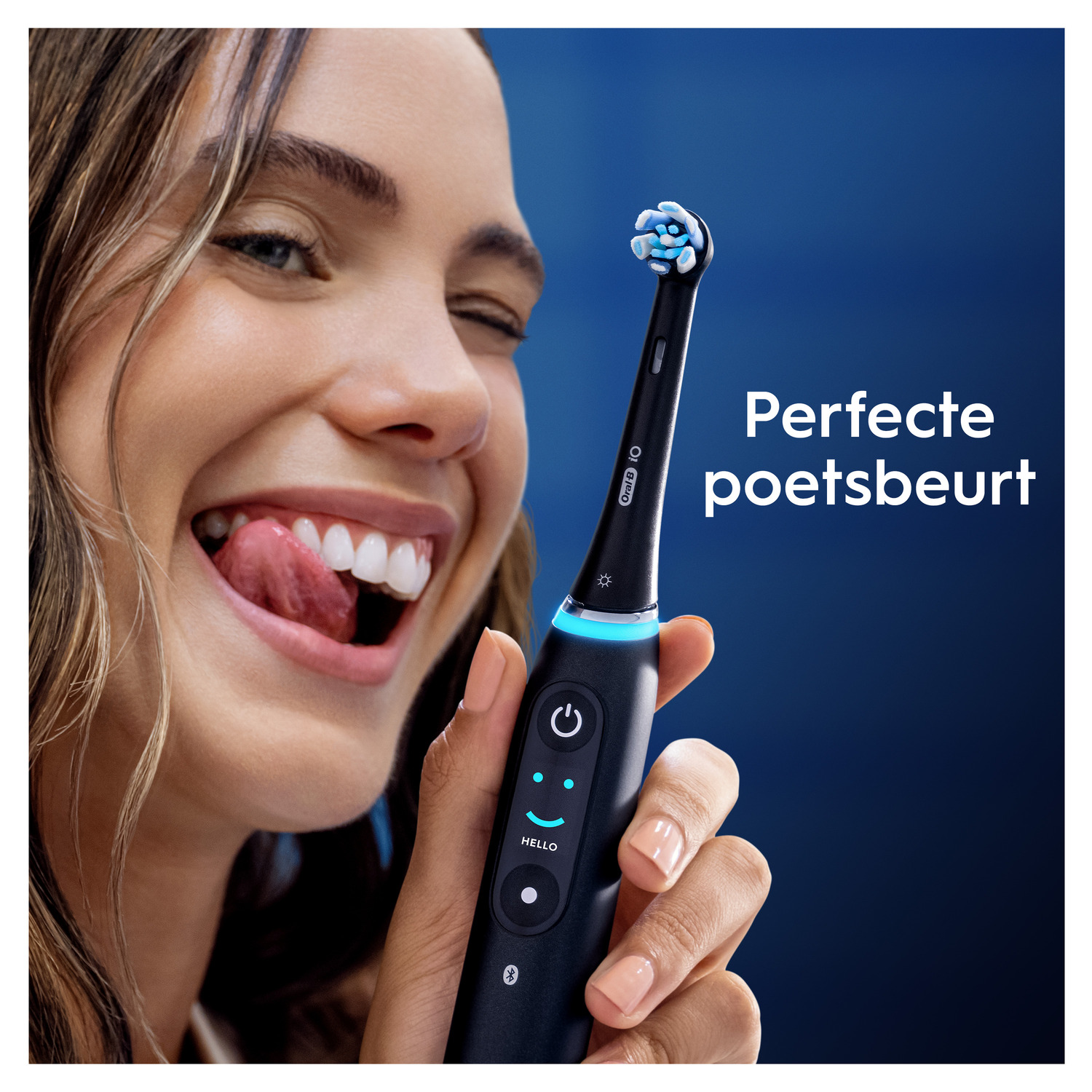 Een vrouw knipoogt terwijl ze een Oral-B tandenborstel met een blauw licht vasthoudt.