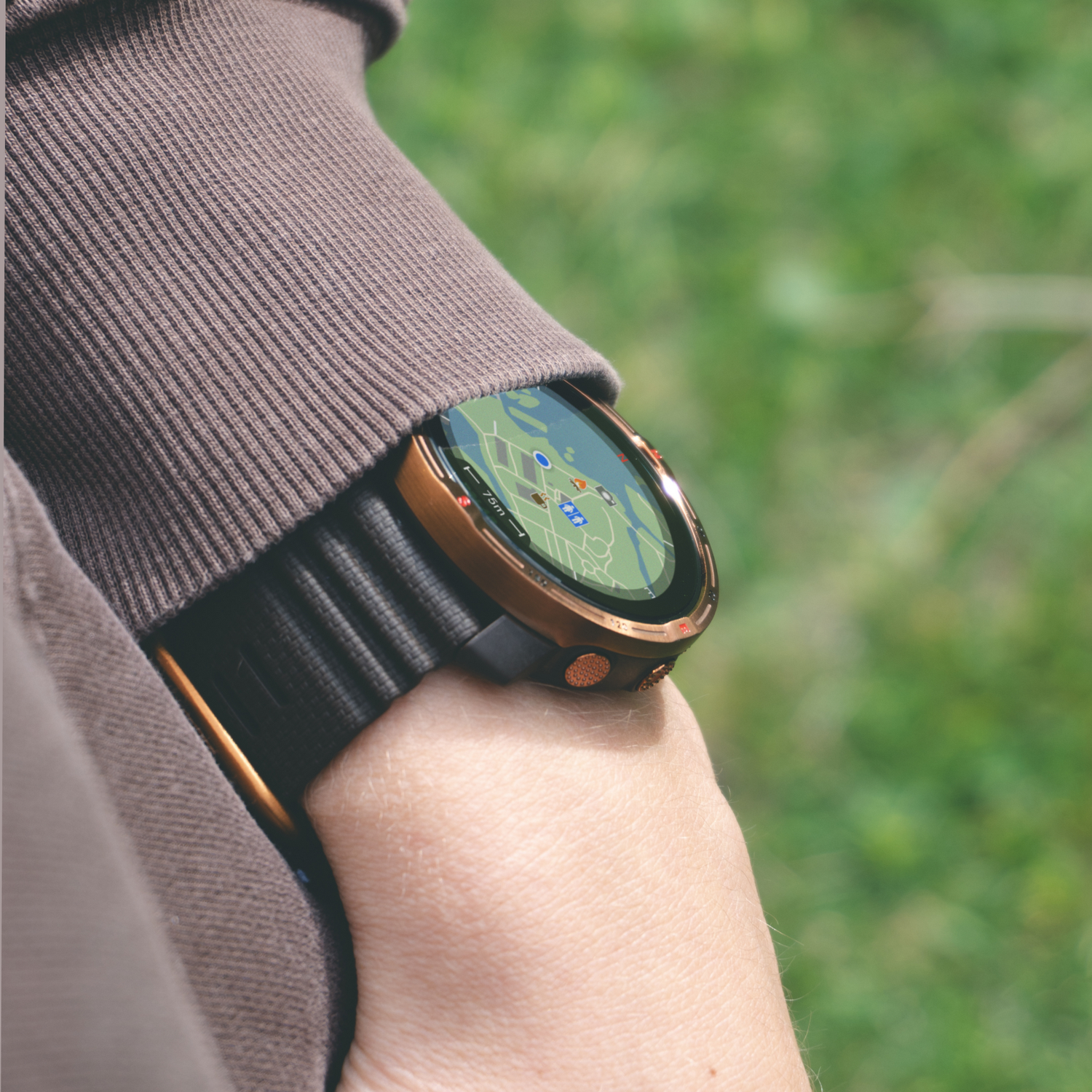 Una persona que lleva un smartwatch en la muñeca, que muestra un mapa. El fondo es una escena borrosa al aire libre.