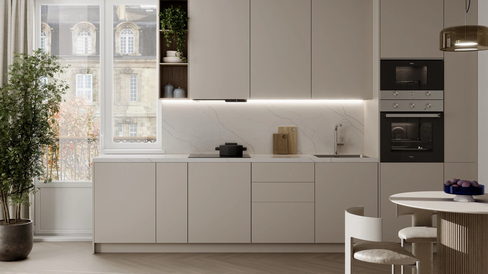 Cocina moderna con armarios beige, una ventana y un árbol.