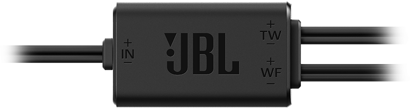 Composant audio JBL noir avec fils et étiquettes. Le fond est noir.