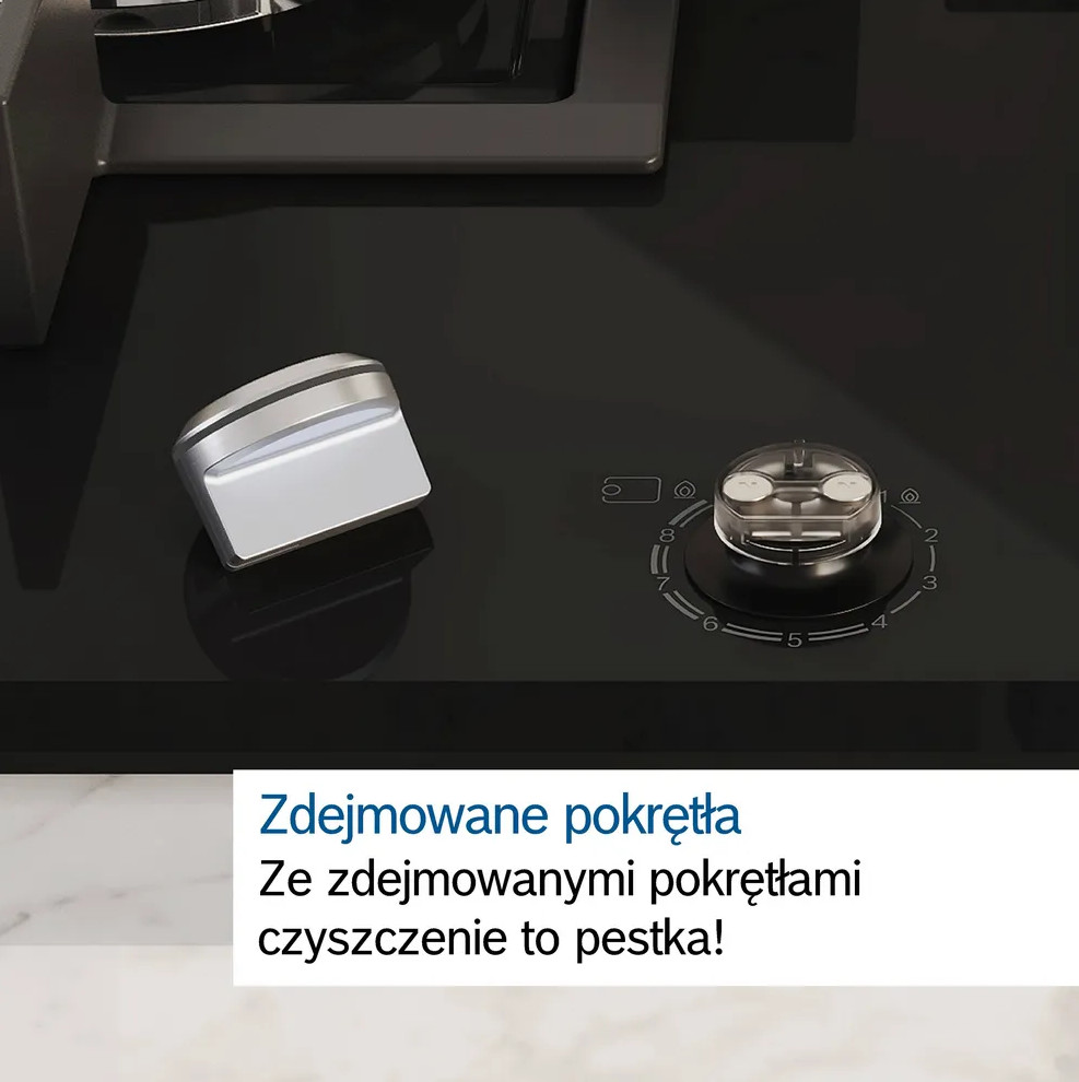 Zbliżenie czarnej kuchenki gazowej z usuniętym pokrętłem. Biały blat w tle.