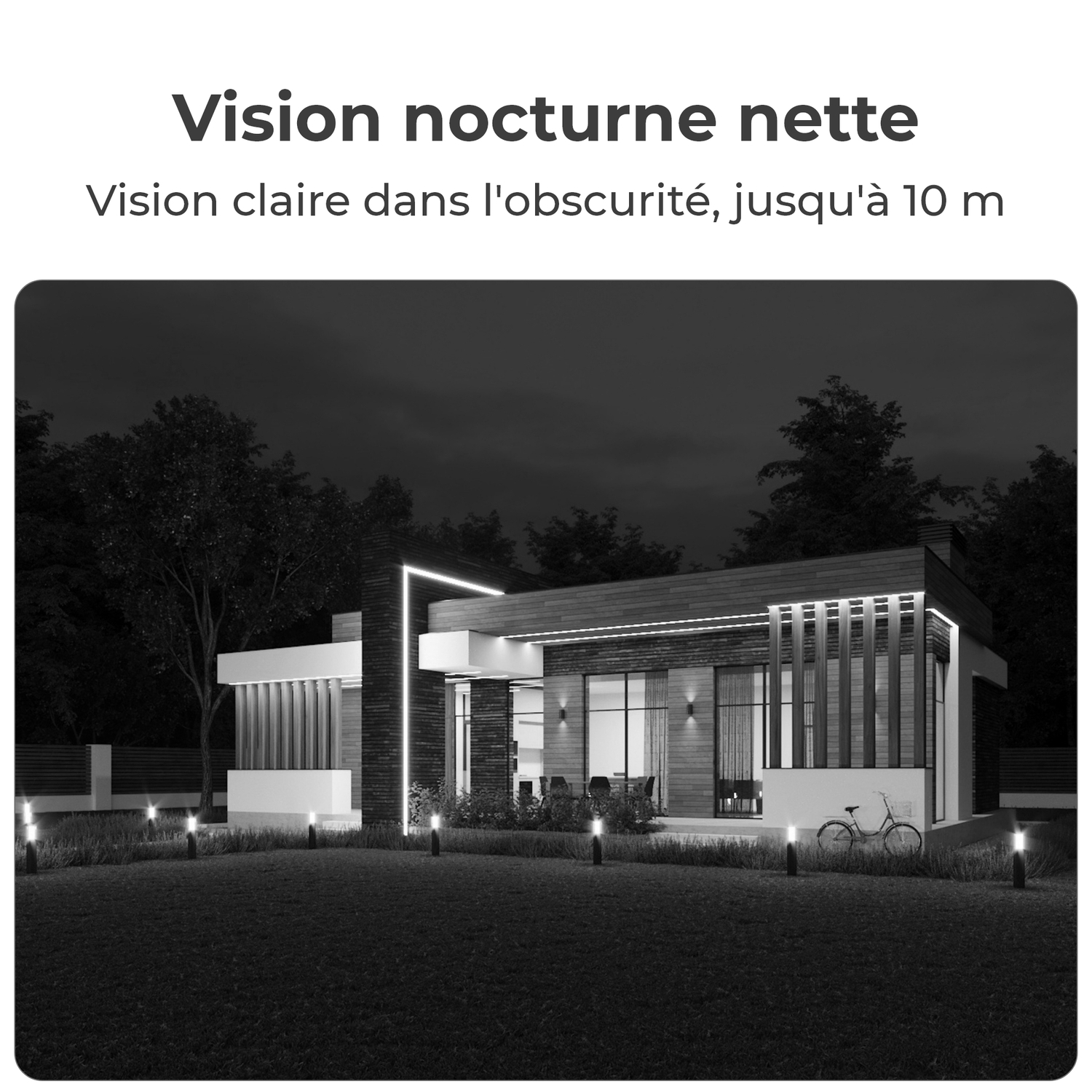 Une vue nocturne d'une maison moderne avec des lumières allumées. L'image est en noir et blanc.