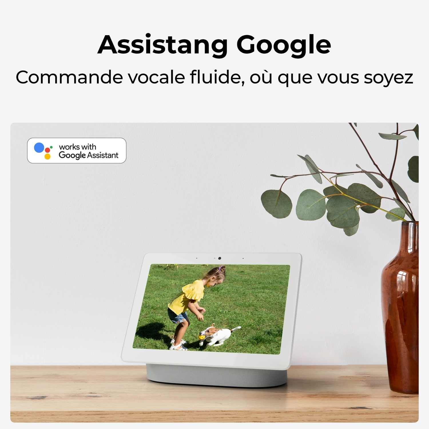 Une tablette affiche un flux vidéo en direct, contrôlé par l'Assistant Google. Une fille joue avec un chien.