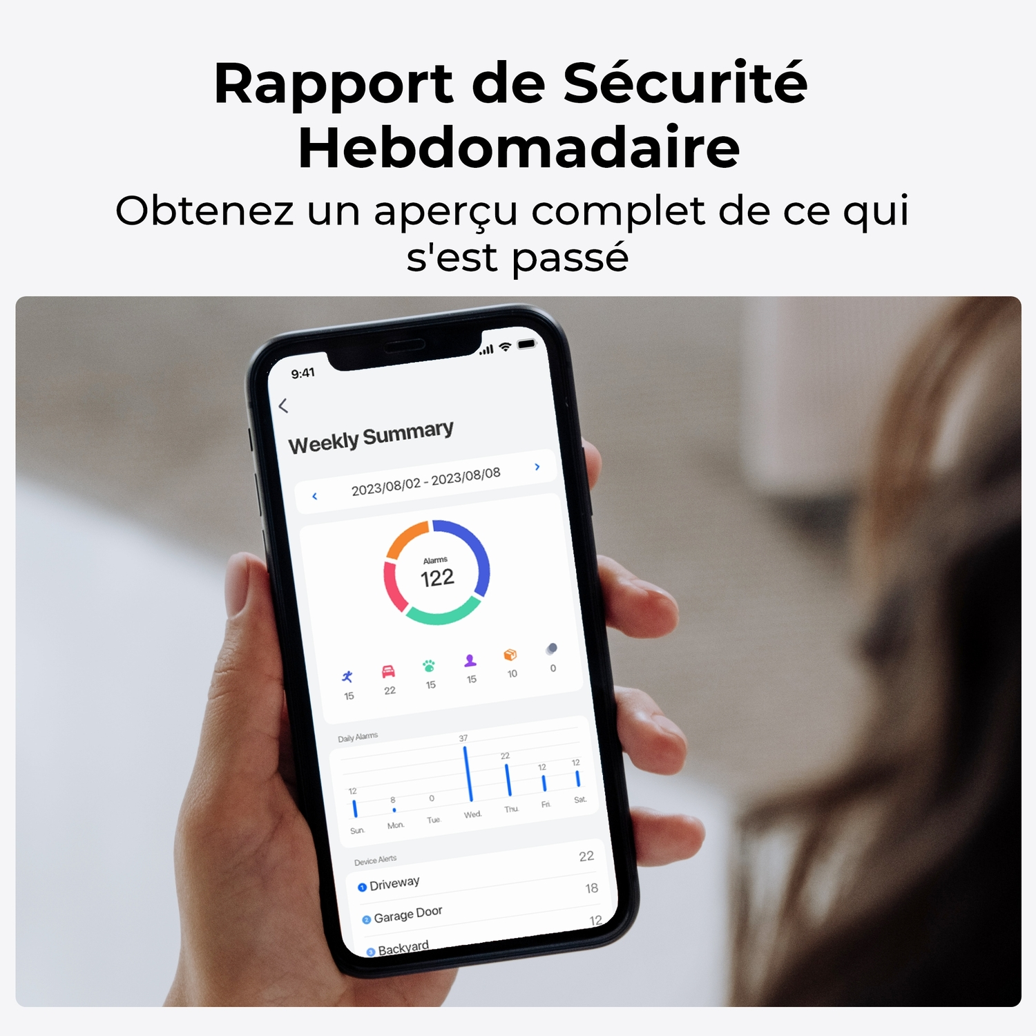 Une main tenant un téléphone affichant un résumé de sécurité hebdomadaire avec des données d'alarmes et des alertes de périphériques.
