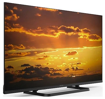 Pochylony telewizor wyświetlający zachód słońca z chmurami i złotym niebem. Logo PEAQ na dole.