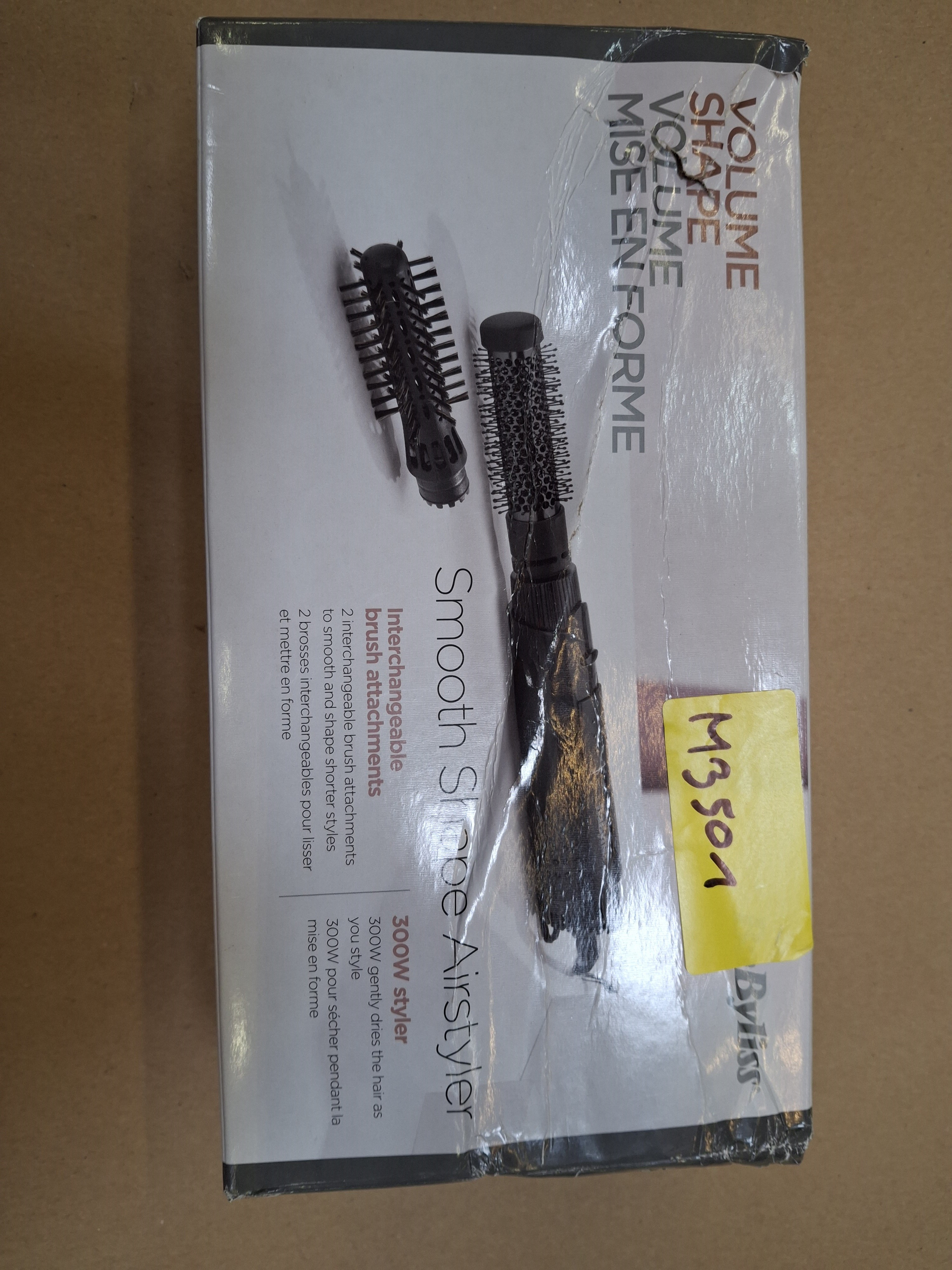 Pudełko z narzędziem do stylizacji włosów, dwoma nasadkami do szczotki i etykietami tekstowymi.