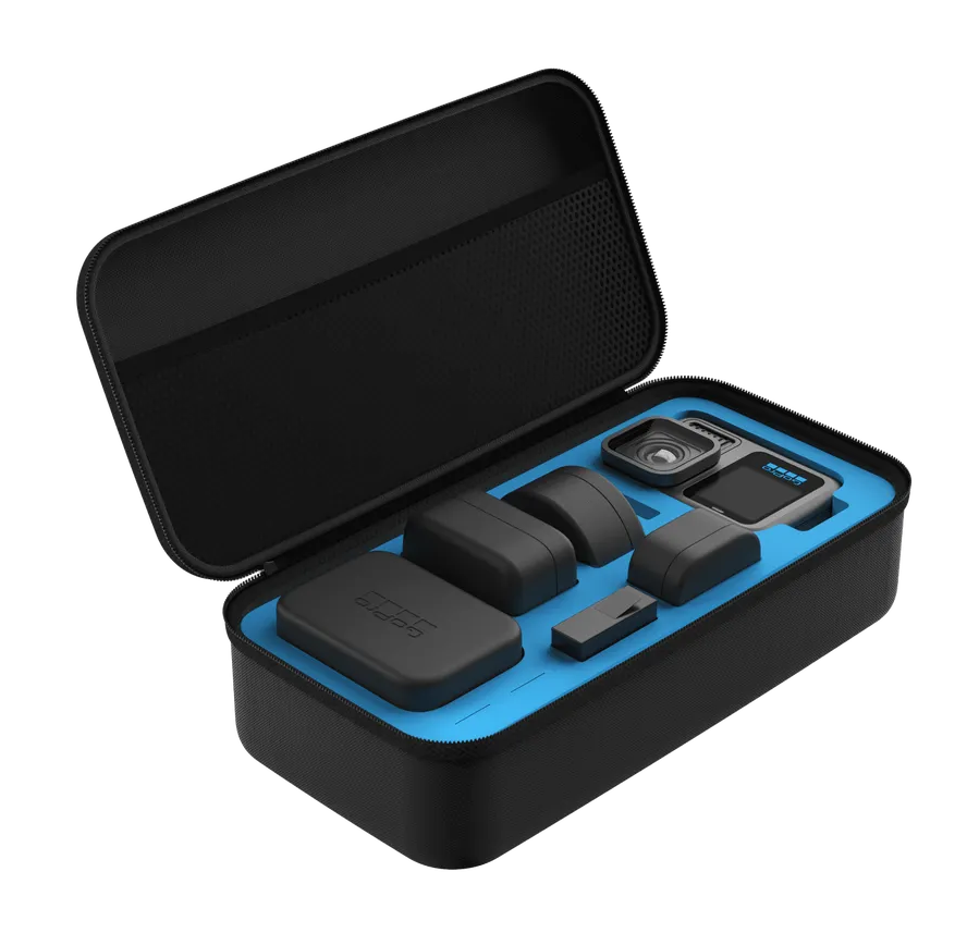 Czarny futerał zawierający aparat, obiektywy i akcesoria. Leży na białej powierzchni.