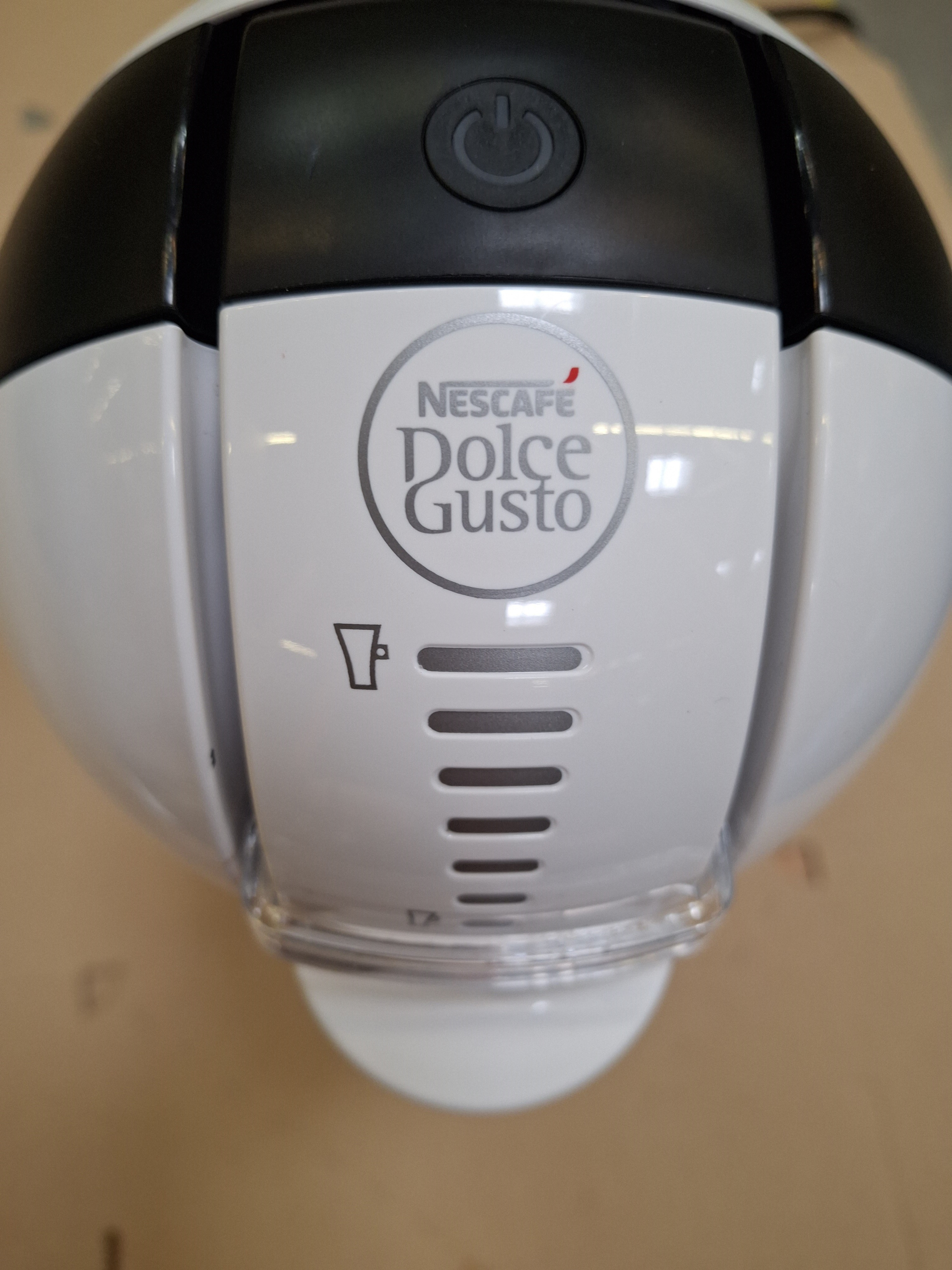 Zbliżenie biało-czarnego ekspresu do kawy Nescafé Dolce Gusto.