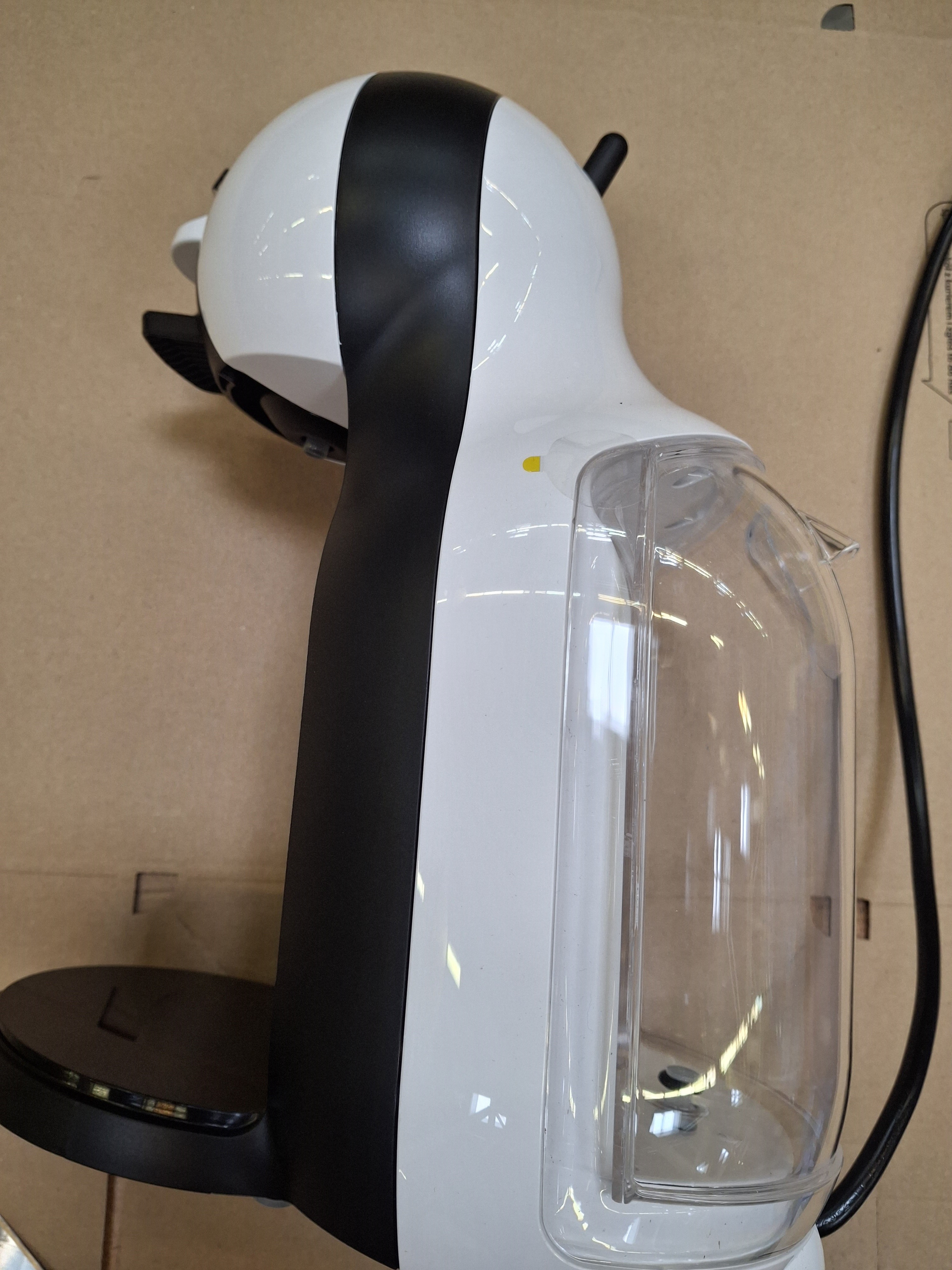 Widok z boku biało-czarnego ekspresu do kawy Nescafé Dolce Gusto.