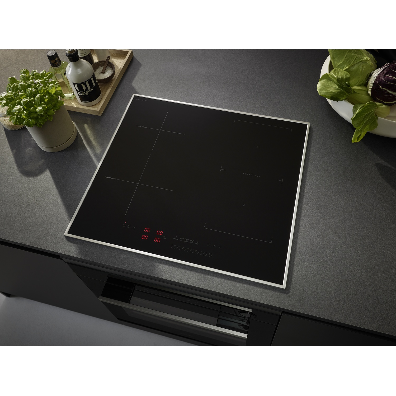 Piano cottura nero con due pentole. Il piano è su una superficie da cucina grigio scuro.