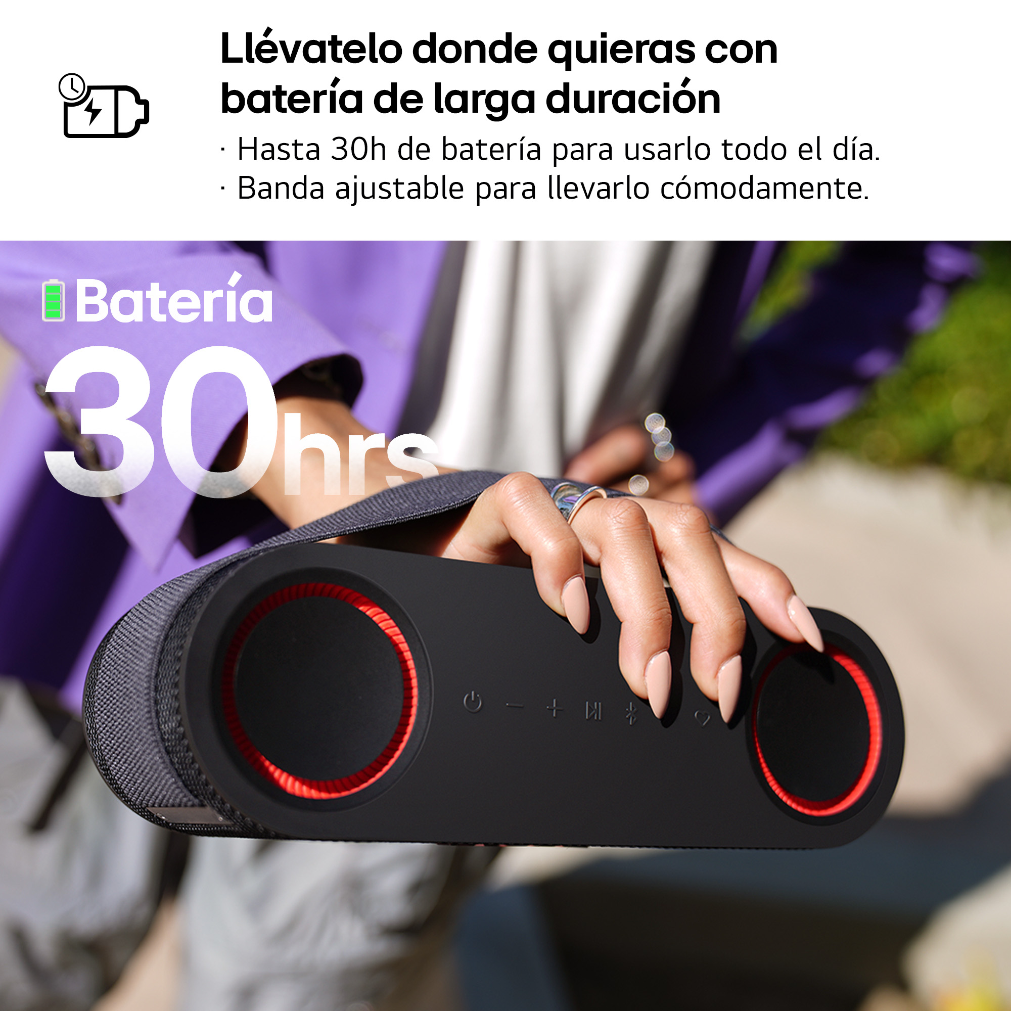 Persona sosteniendo altavoz negro con detalles rojos. Duración de la batería 30 horas. Correa ajustable.