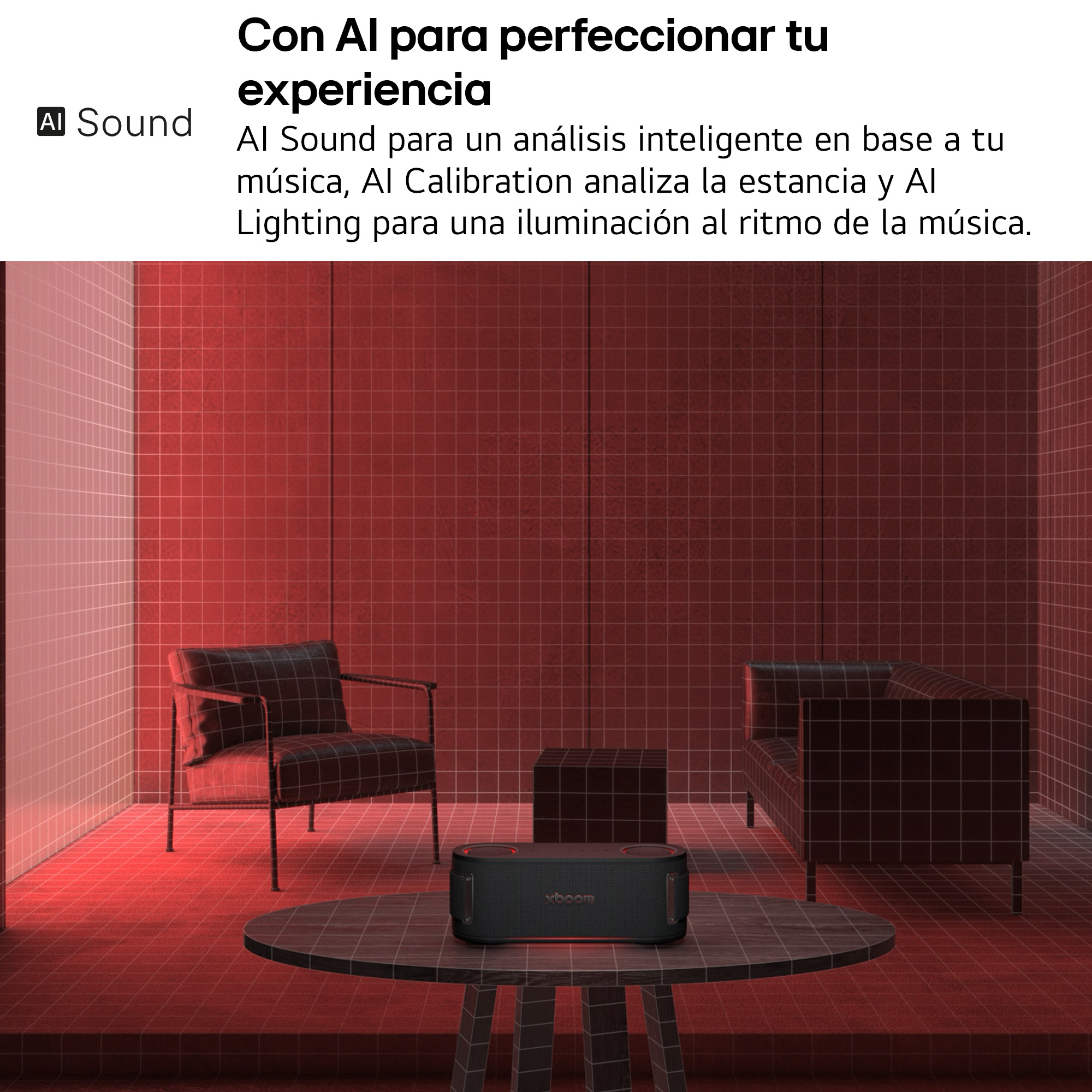 Altavoz negro sobre mesa en habitación con luz roja. Dos sillas y un sofá al fondo.