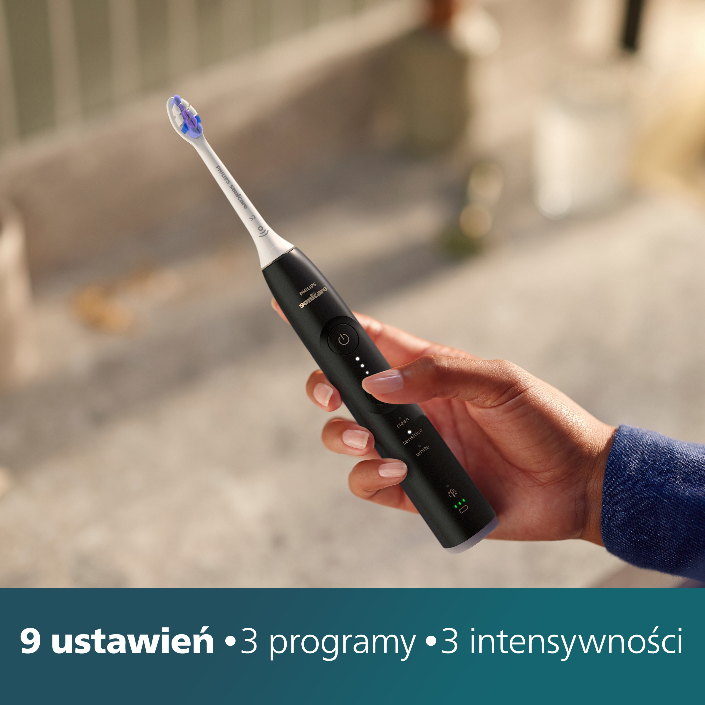Dłoń trzyma czarną szczoteczkę Philips Sonicare. Tekst: 9 ustawień, 3 programy, 3 intensywności.