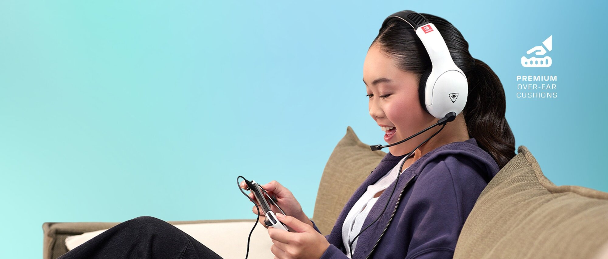 Una giovane donna seduta, che gioca a un gioco su un Switch, indossa cuffie bianche con microfono.