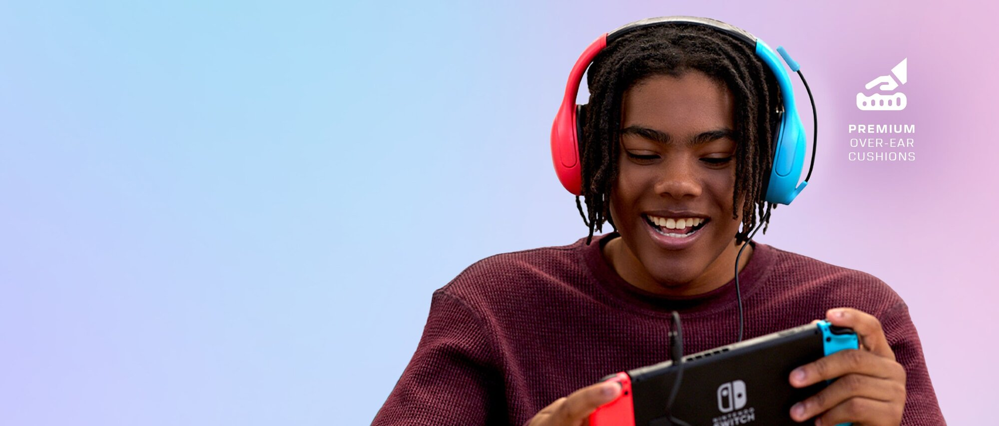 Ein junger Mann spielt Nintendo Switch mit rot-blauen Kopfhörern.