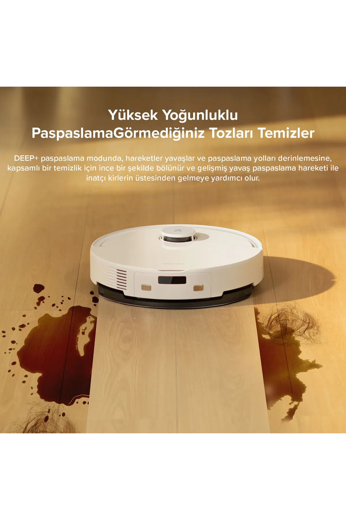 Beyaz robot süpürge, kahverengi bir lekeyle ahşap bir zeminde temizlik yapıyor.