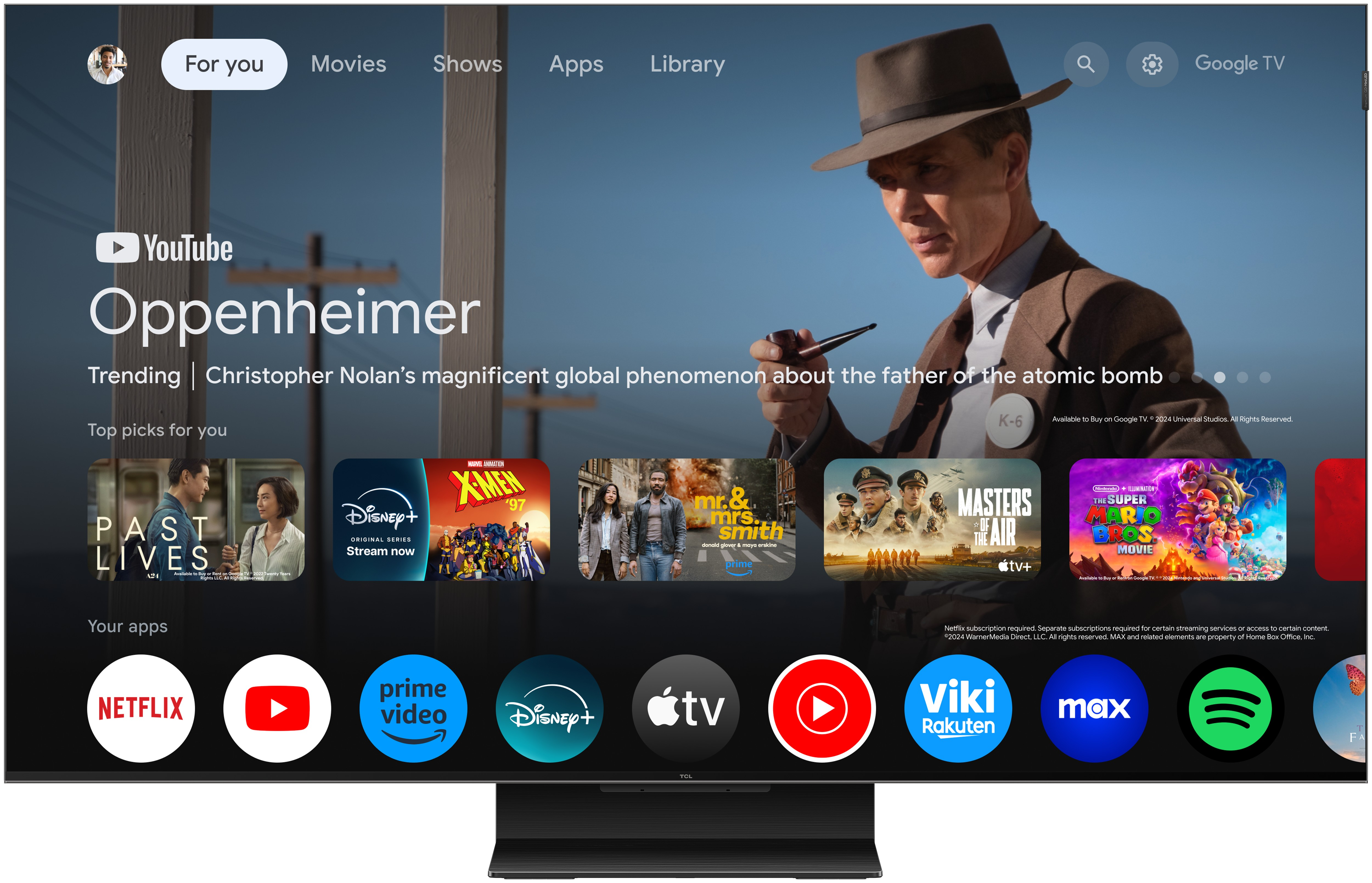 Un écran de télévision affichant l'interface Google TV avec 'Oppenheimer' et des icônes d'applications.