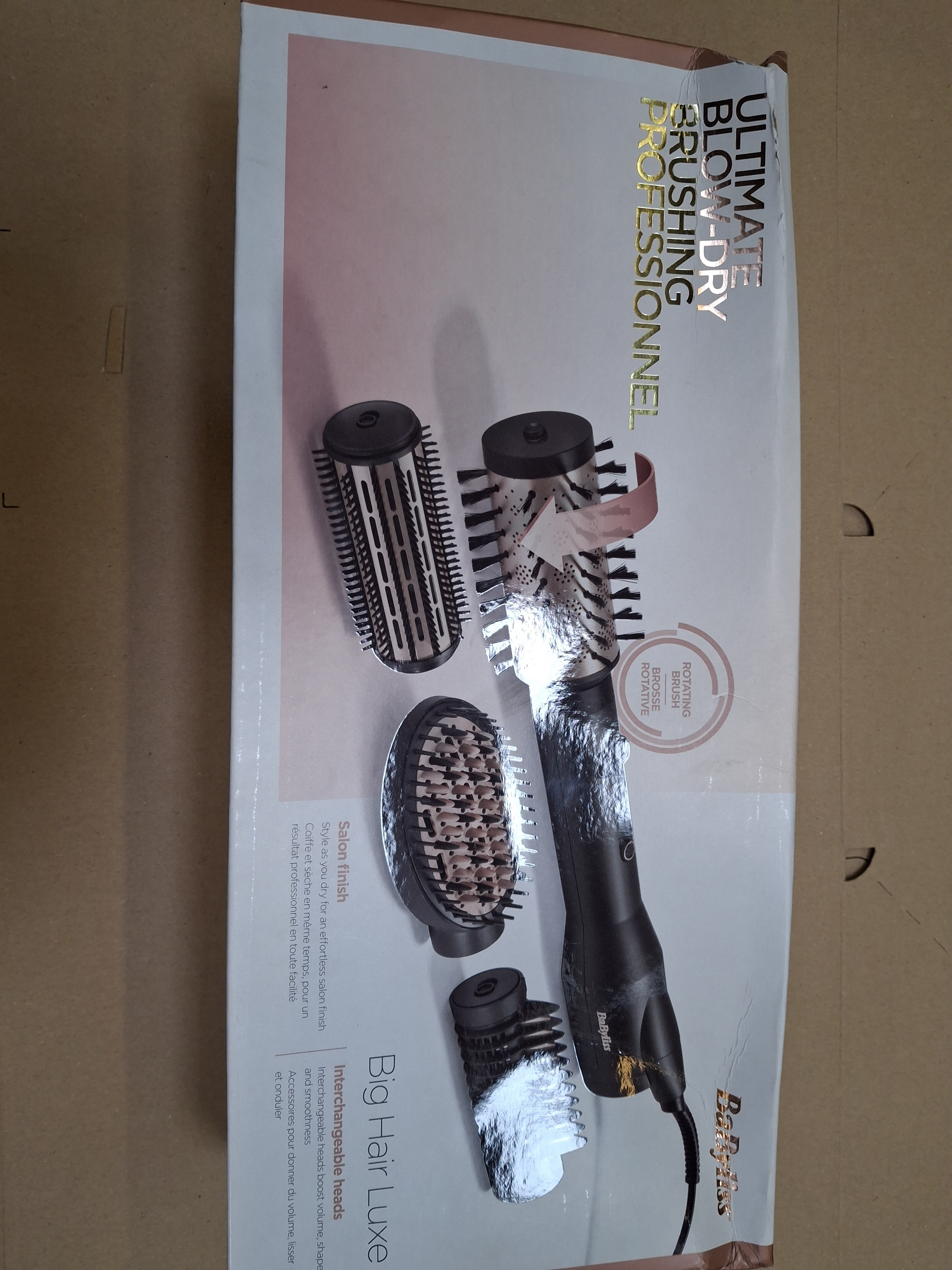 Pudełko z akcesoriami do stylizacji włosów. Zawiera szczotki i podstawę suszarki do włosów. Tekst brzmi „Professional”.