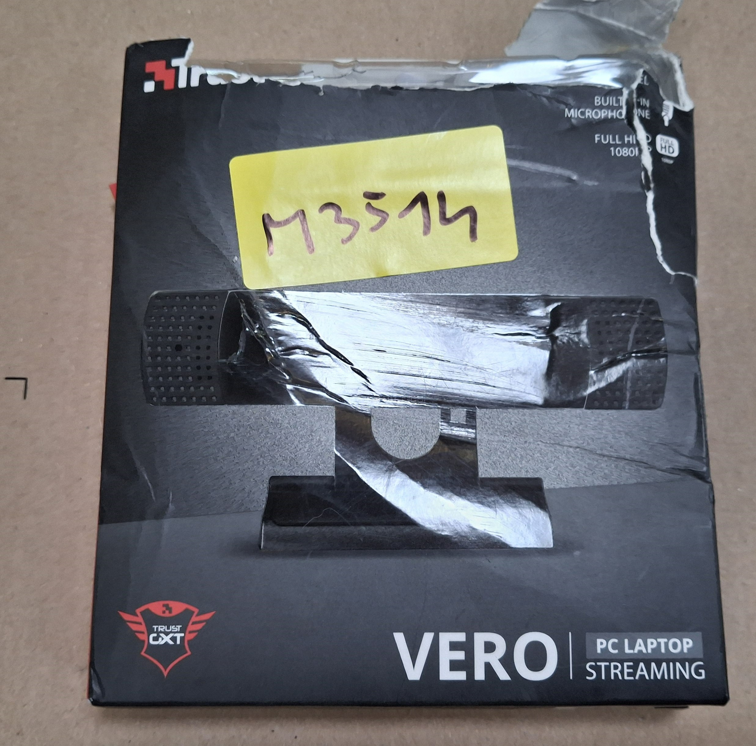 Zapakowana kamerka internetowa Trust Vero. Czarna kamerka w pudełku z naklejką. Czarne pudełko ze szczegółami produktu.