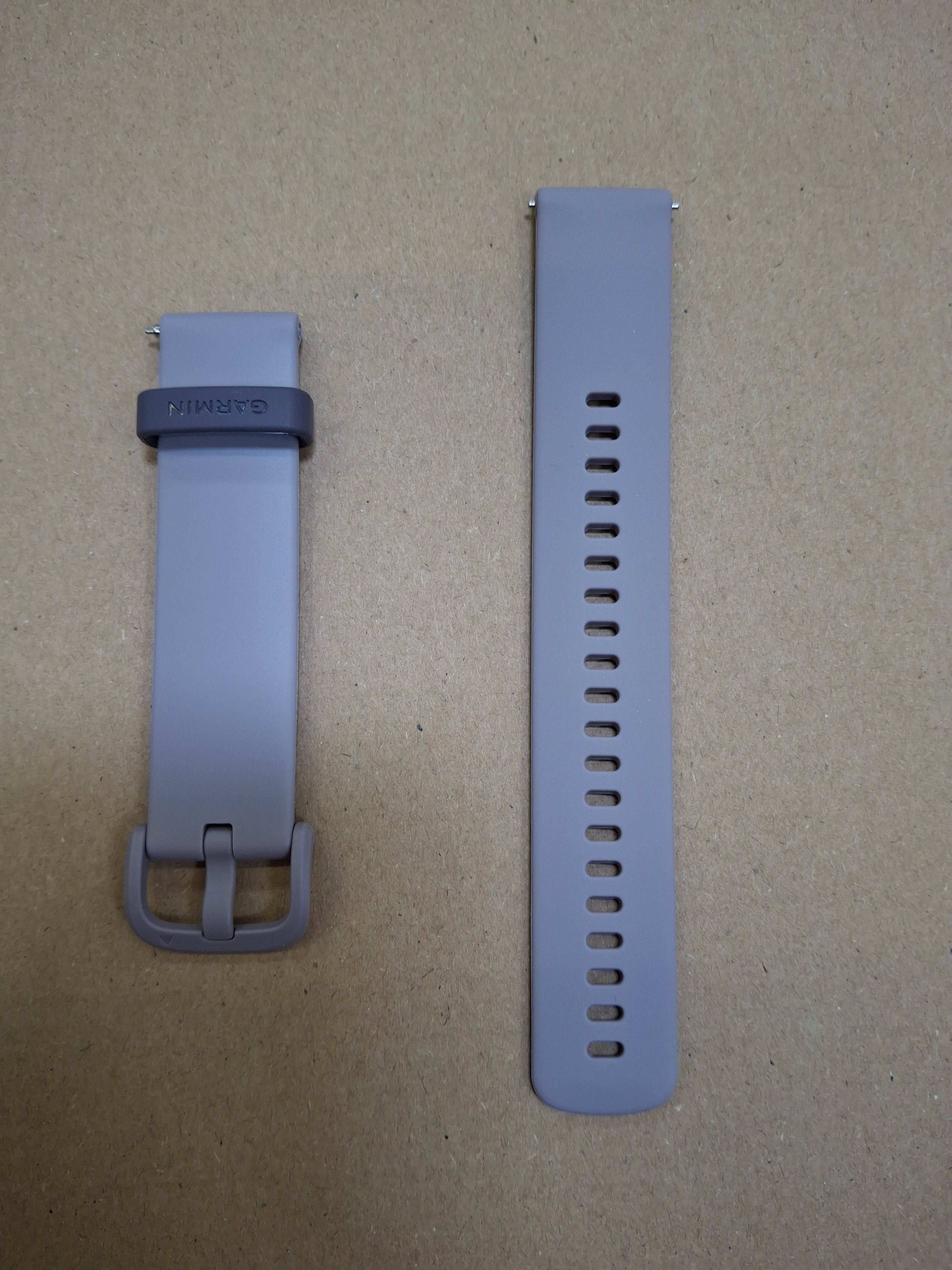 Dwa szare paski do zegarka Garmin. Jeden z klamrą, drugi z otworami do regulacji.