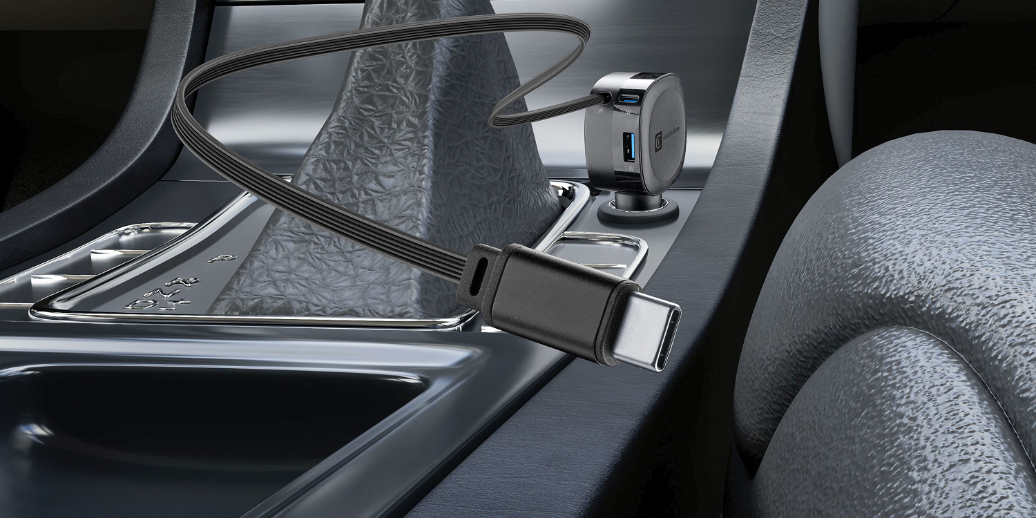 Interior del coche con cargador y cable USB-C. Palanca de cambios metálica e interior negro.