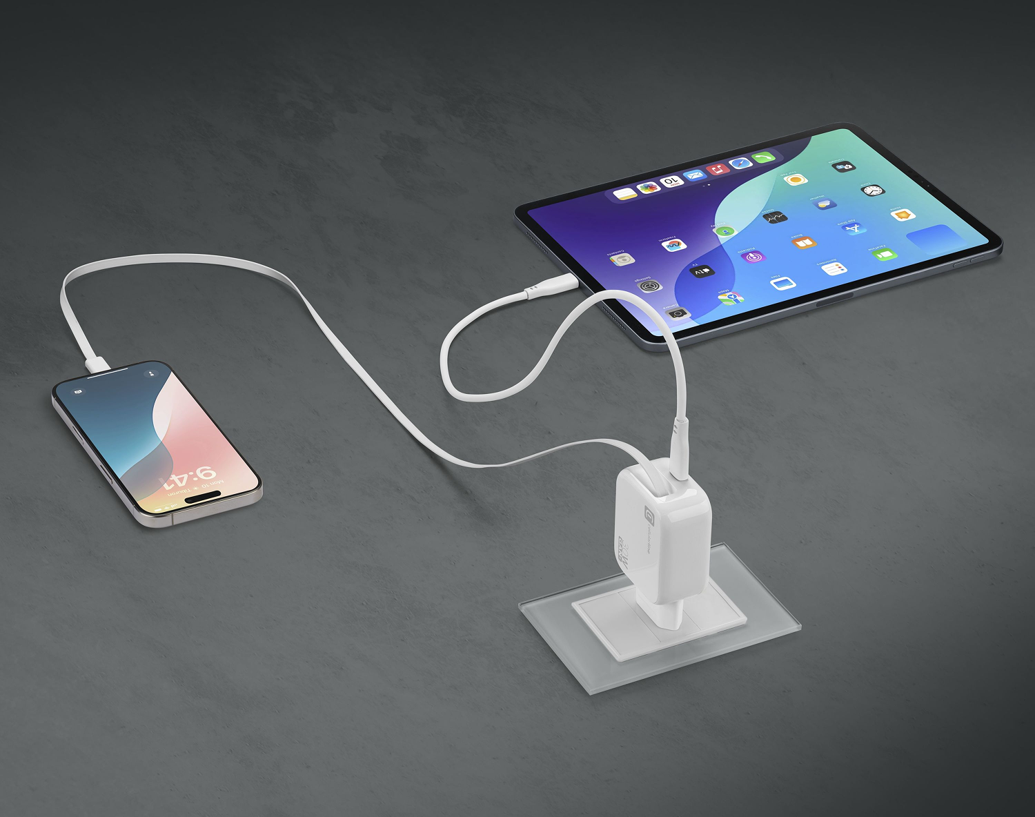 Un teléfono y una tableta se cargan con un cargador blanco. El cargador está en una base blanca.
